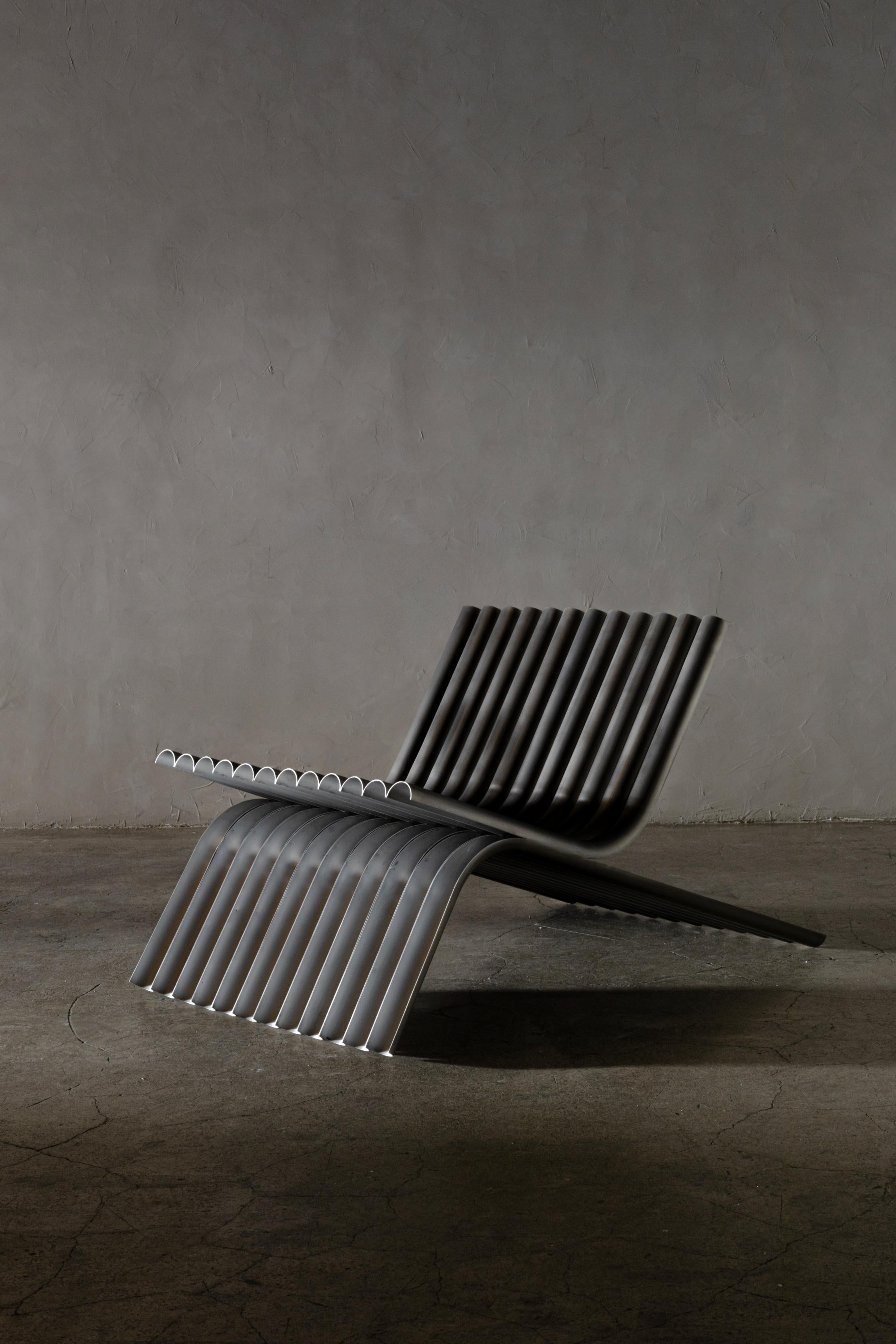 OBJ-02 steel lounge chair by Manu Bano.
Dimensions: 100 L X 60 W X 60 H cm.
Material: Steel.

OBJ-02 is a low chair composed of a repetition of brass tubes. Each one is cut in half and bent independently, creating the back, seat and legs.

The
