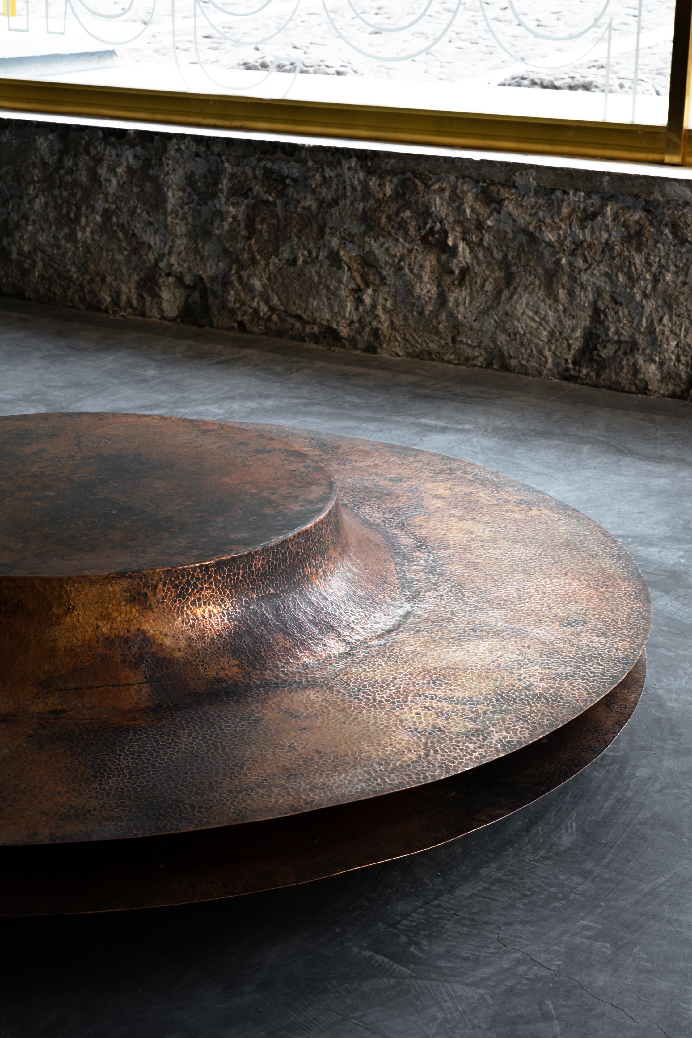 OBJ-06 copper coffee table by Manu Bano
Dimensions: D 170 x H 35 cm
Material: Copper

Manu Bañó's new collection explores the limits and properties of copper. It was produced in Santa Clara Del Cobre, Michoacán, a magical town with a long