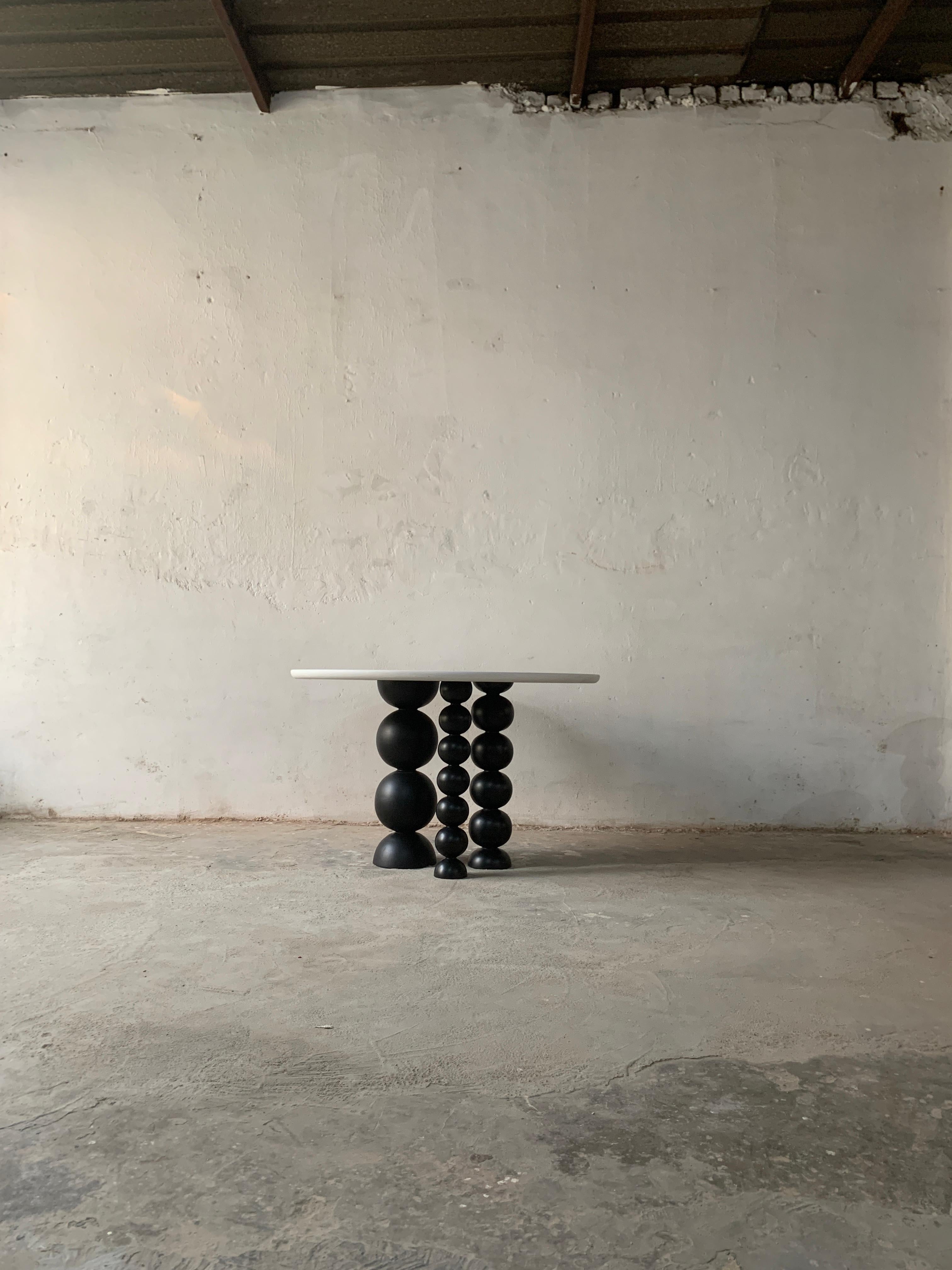 A modern and refined addition to your dining space, this dining set brings together simplicity, elegance, and comfort in one cohesive design. It features a round tabletop with a smooth white stucco finish, supported by a sculptural ball pack pillar