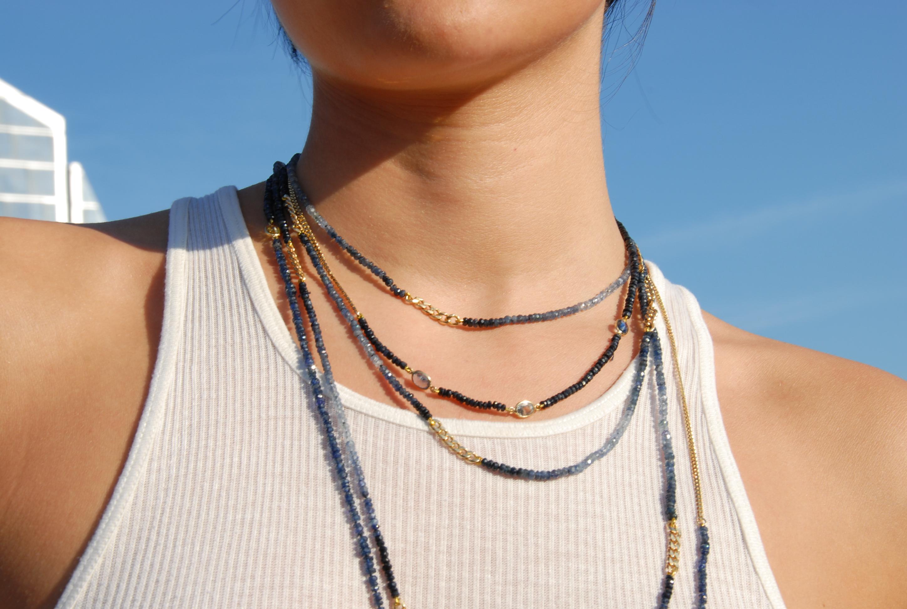 Hand-knotted beaded necklace composed of blue ombre sapphire beads and 18k yellow gold  curb chain. 
 
16 inches long
Ombre blue to white sapphire beads
18k yellow gold chain

* Model is layering this 16 inches necklace with other beaded necklaces