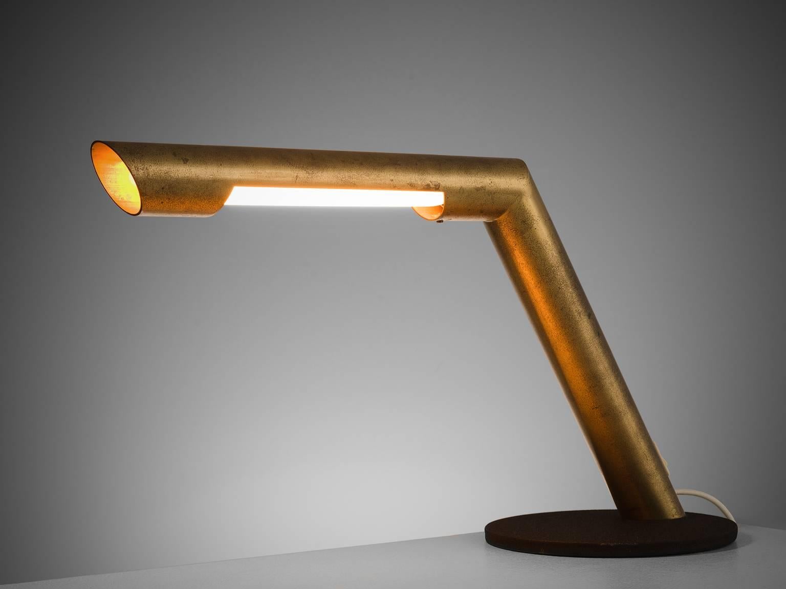 Tubular desk light, made with brass, Italy, 1960s. 

Simple but sculptural desk light, made by an oblique brass bent pole. The light is balanced by the heavy brass base. There are three holes in which the light comes out, one on the bottom, one on