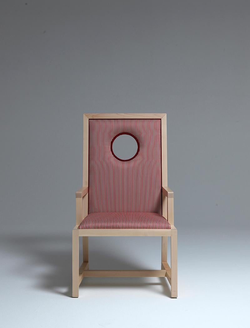 Oblo`. chair or armchair in natural maple wood and striped red and white fabric upholstery.
Aldo Cibic has designed an unexpected seat with generous dimensions, with a round window on the back that recalls the yachts portholes.