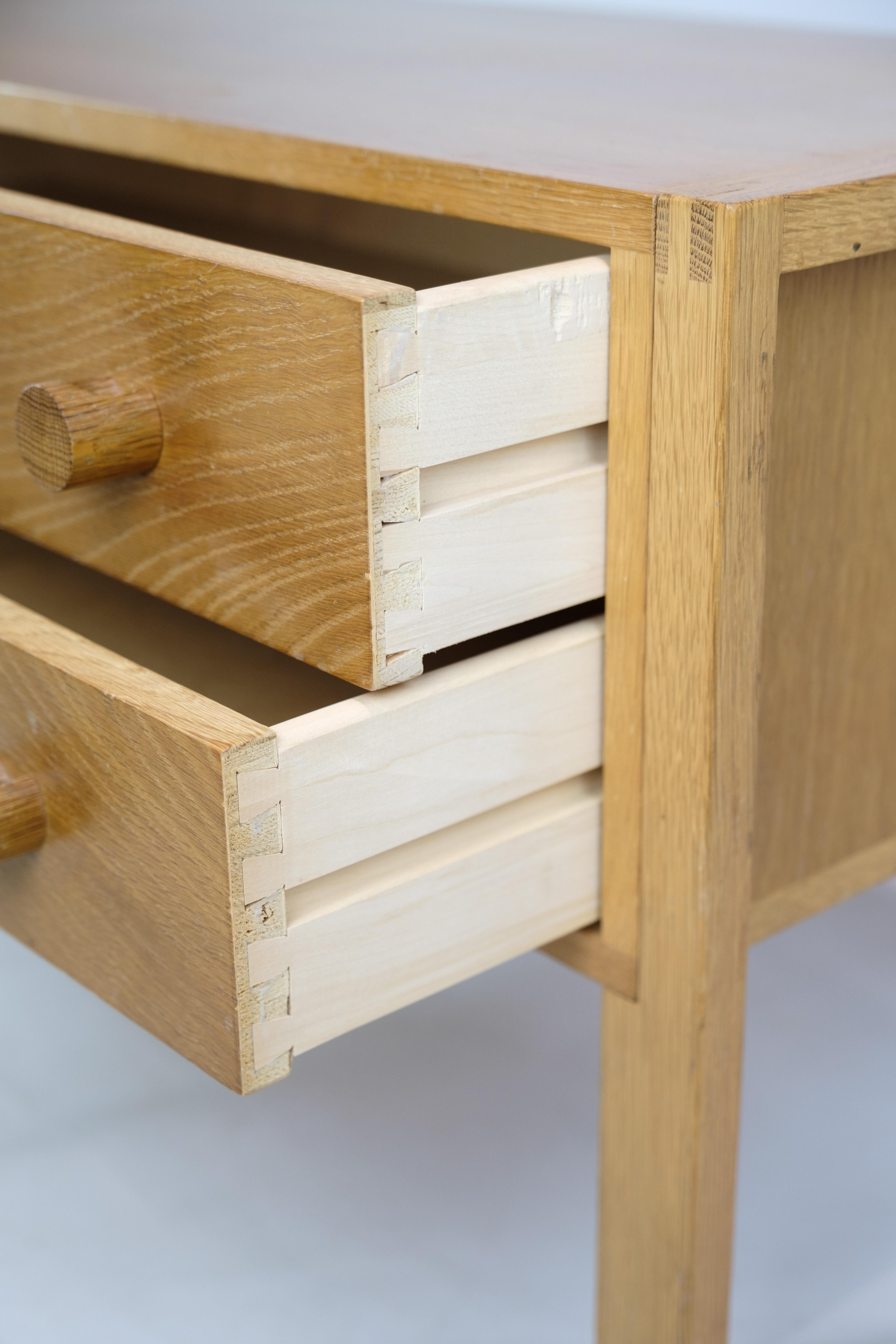 Oblong chest of drawers in oak with 2 drawers and wooden handles of Danish furniture design from around the 1960s. The furniture appears in very fine used condition and is well suited to be both entrance furniture, as well as storage