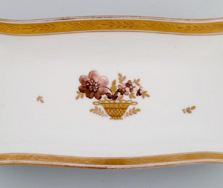 Oblong Royal Copenhagen Golden Basket serving dish in porcelain with flowers and gold decoration. 
Model number 595/9442. 
Early 20th century.
Measures: 36 x 14 x 4 cm.
In excellent condition.
Stamped.
2nd factory quality.