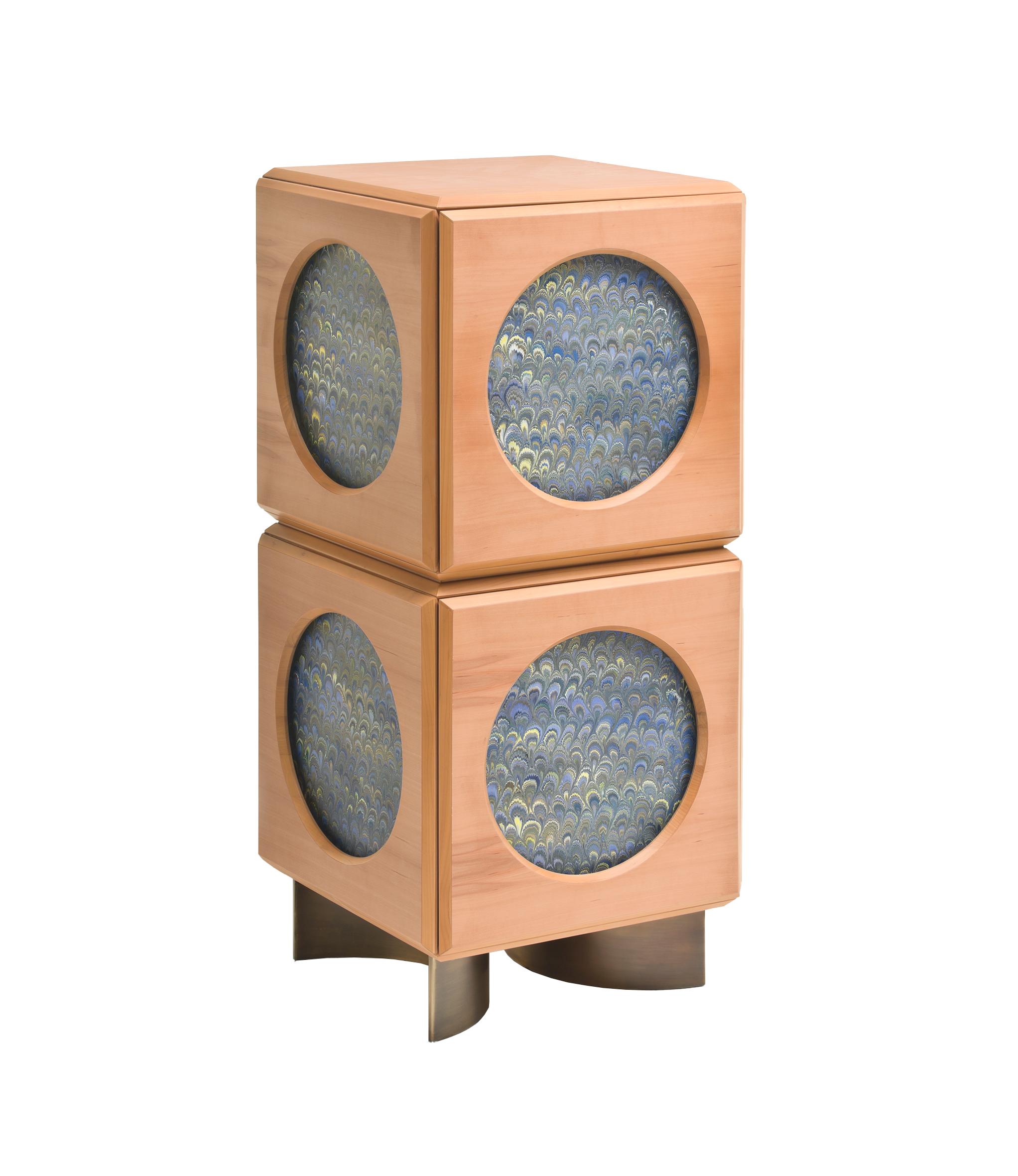 Oblù, entworfen von Analogia Project, ist ein geheimnisvoller Behälter, eine magische Kiste, die ihre Verwendung teilweise verbirgt und teilweise offenbart. Die elegante rechteckige Struktur aus Birnbaumholz, die von zwei Halbkreisen aus brüniertem