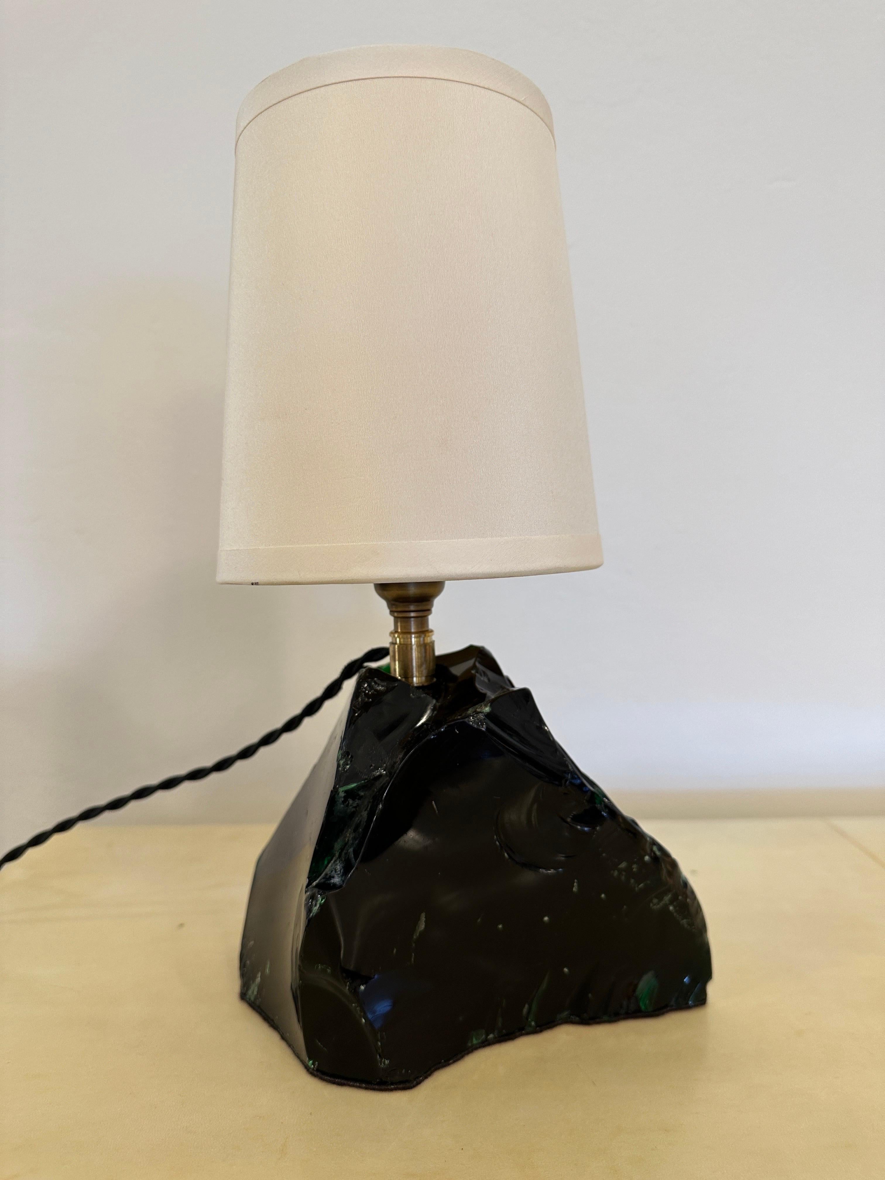 This wonderful Obsidian glass chunk has hints of deep emerald green in the light but mostly comes across as black. It is a wonderful element with NEWLY silk wired cable and plug. A fantastic lamp for any décor in the manner of JMF and designed