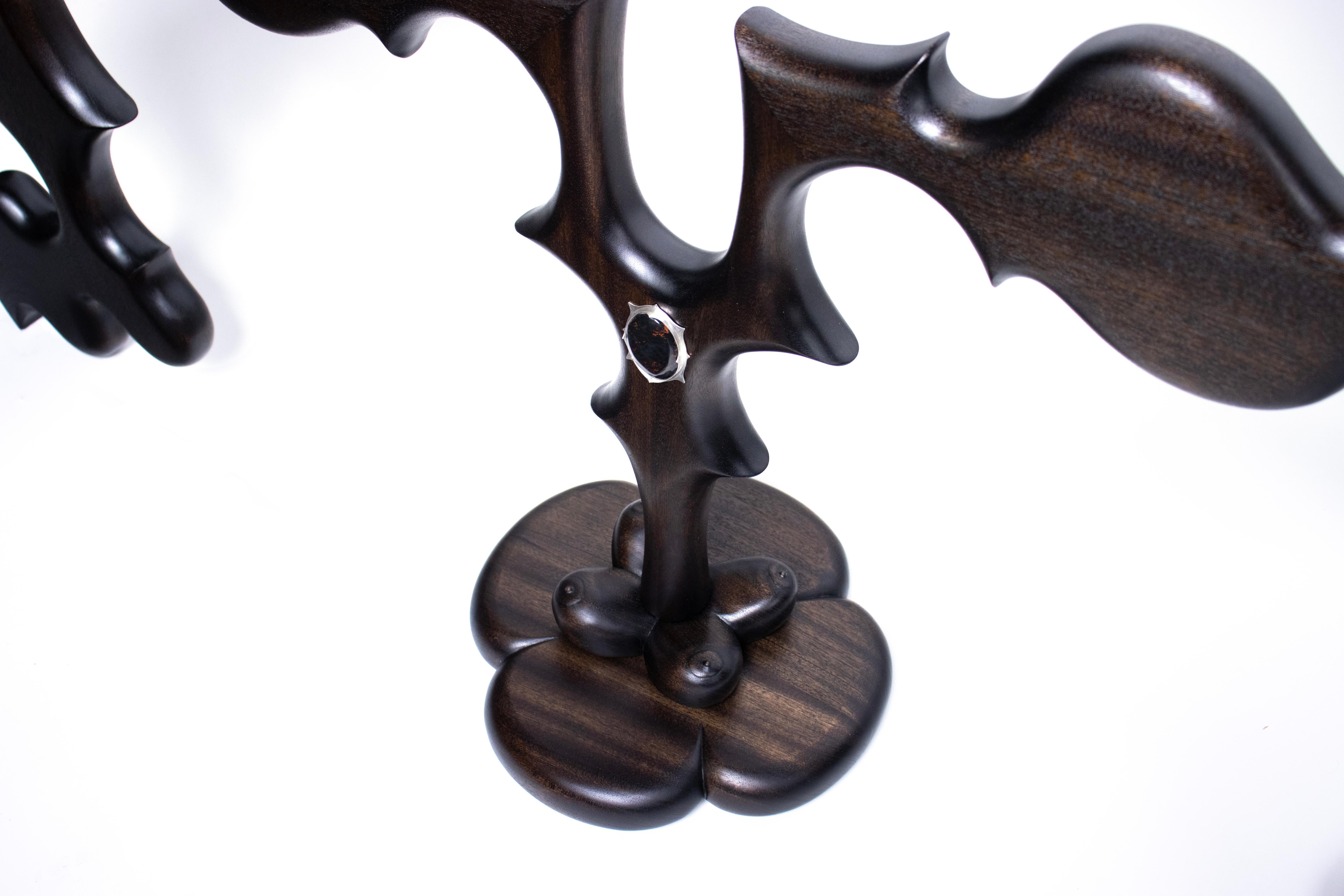 Drawing influence from baroque and rococo design, the Obsidian Seraphim console table takes Ezekiel’s description of the seraphim and twists it into a biomorphic sculpture that undulates with blasphemous idolatry. The hand carved forms dance and