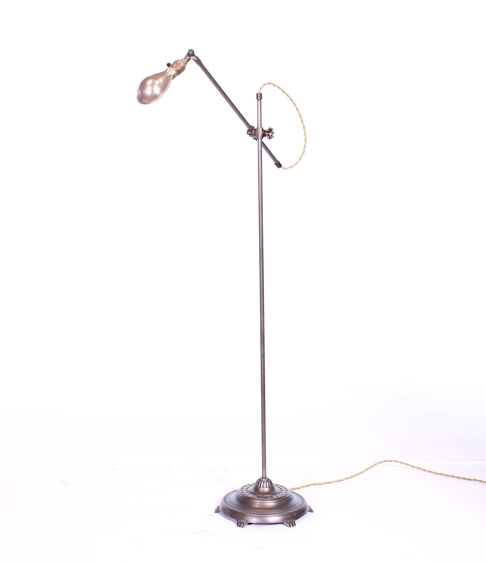 Antique OC white adjustable floor / reading / task lamp with claw foot base and silver shade. Cast iron base measures 12
