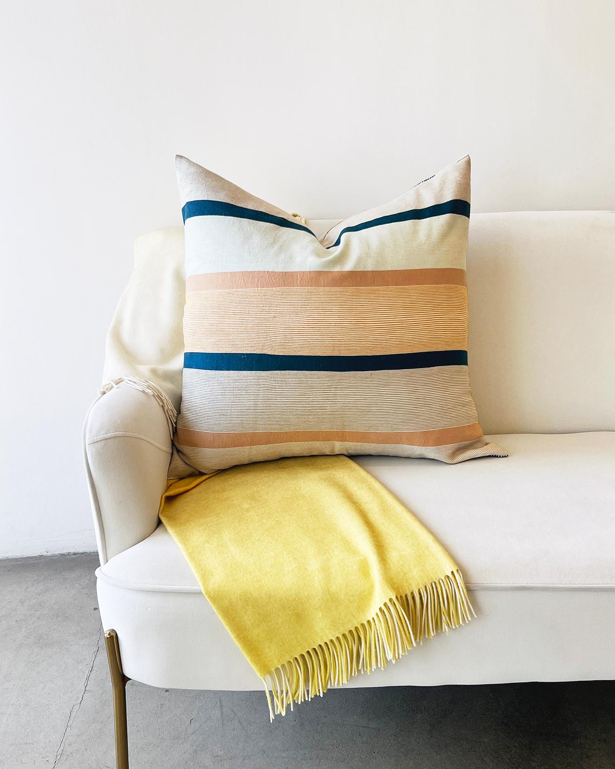 Experience the vibrant colors and bold stripes of the Ocaso Pillow. These handcrafted, fair-trade, high-end throw pillows are the perfect accent to Mexican and Latin American home décor. Designed with local materials, each cushion will add a burst