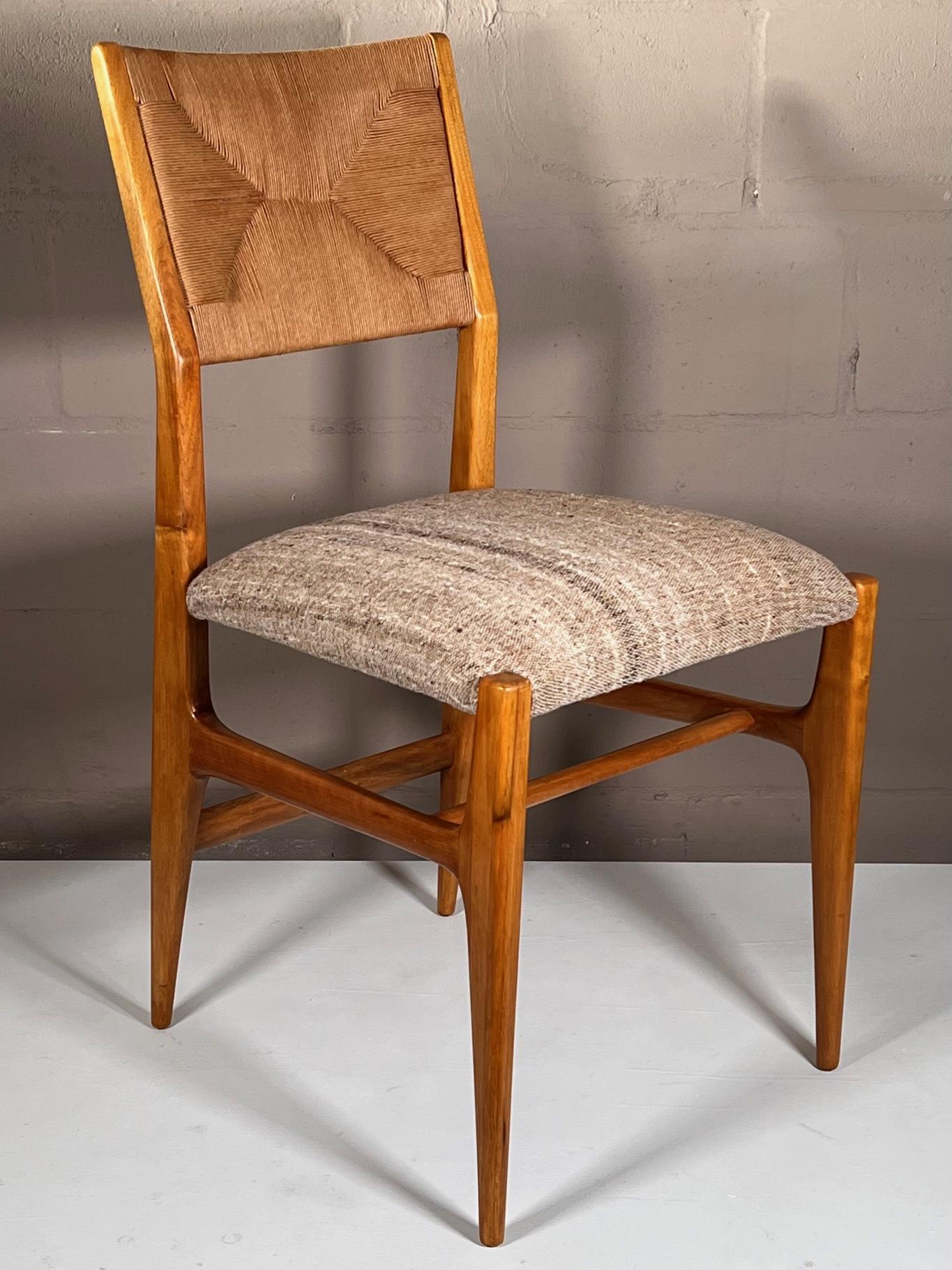 A beautiful, vintage dining/desk/occasional chair by Gio Ponti for Singer&Sons, ca' 1950's. Restored with wool seats by Larsen fabric, papercord backs. These chairs are classics that will never go out of style. A total of two (2) available.