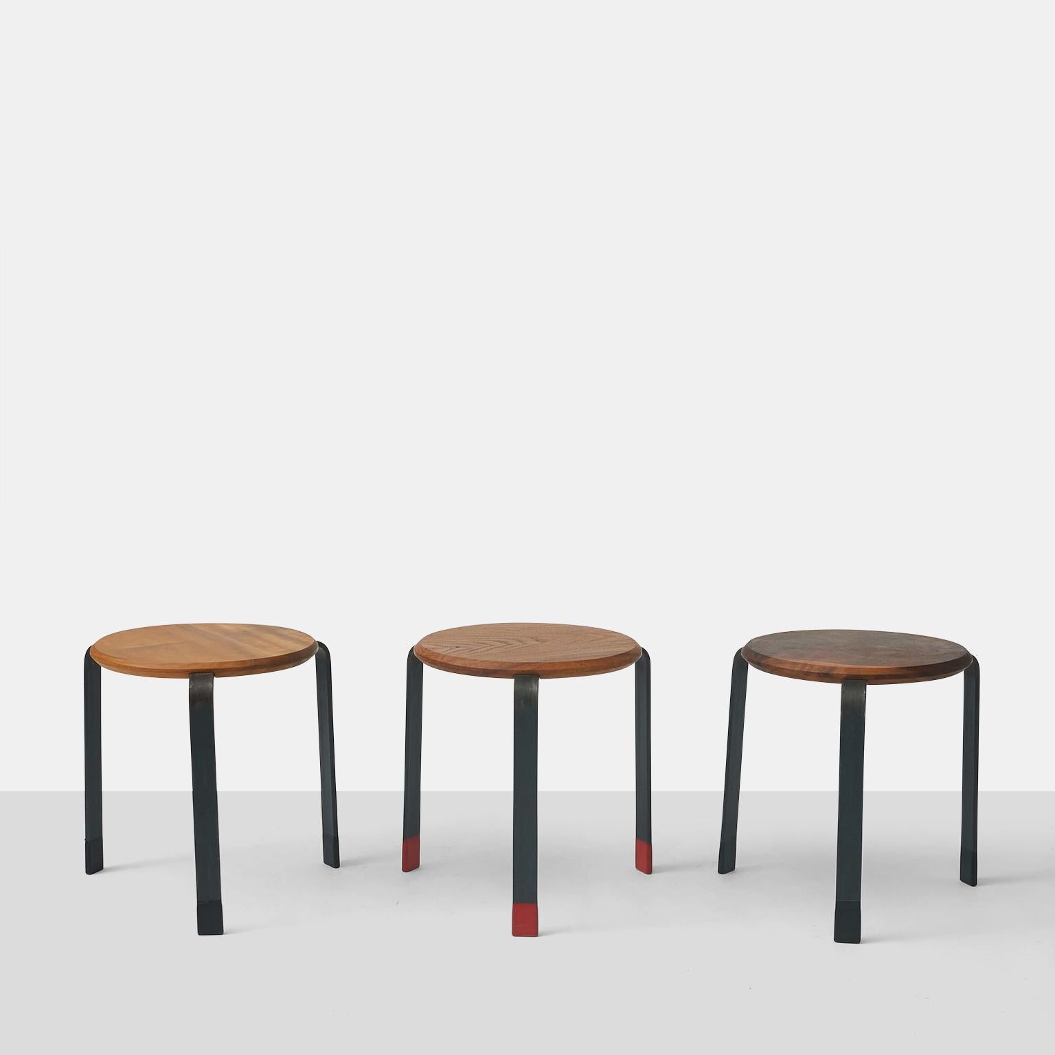 A pair of stools or small occasional tables of various woods. Each feature steel legs, with painted feet. Designed and manufactured in San Francisco by Josh Duthie. Have only the black feet left. 
Price for the pair. 