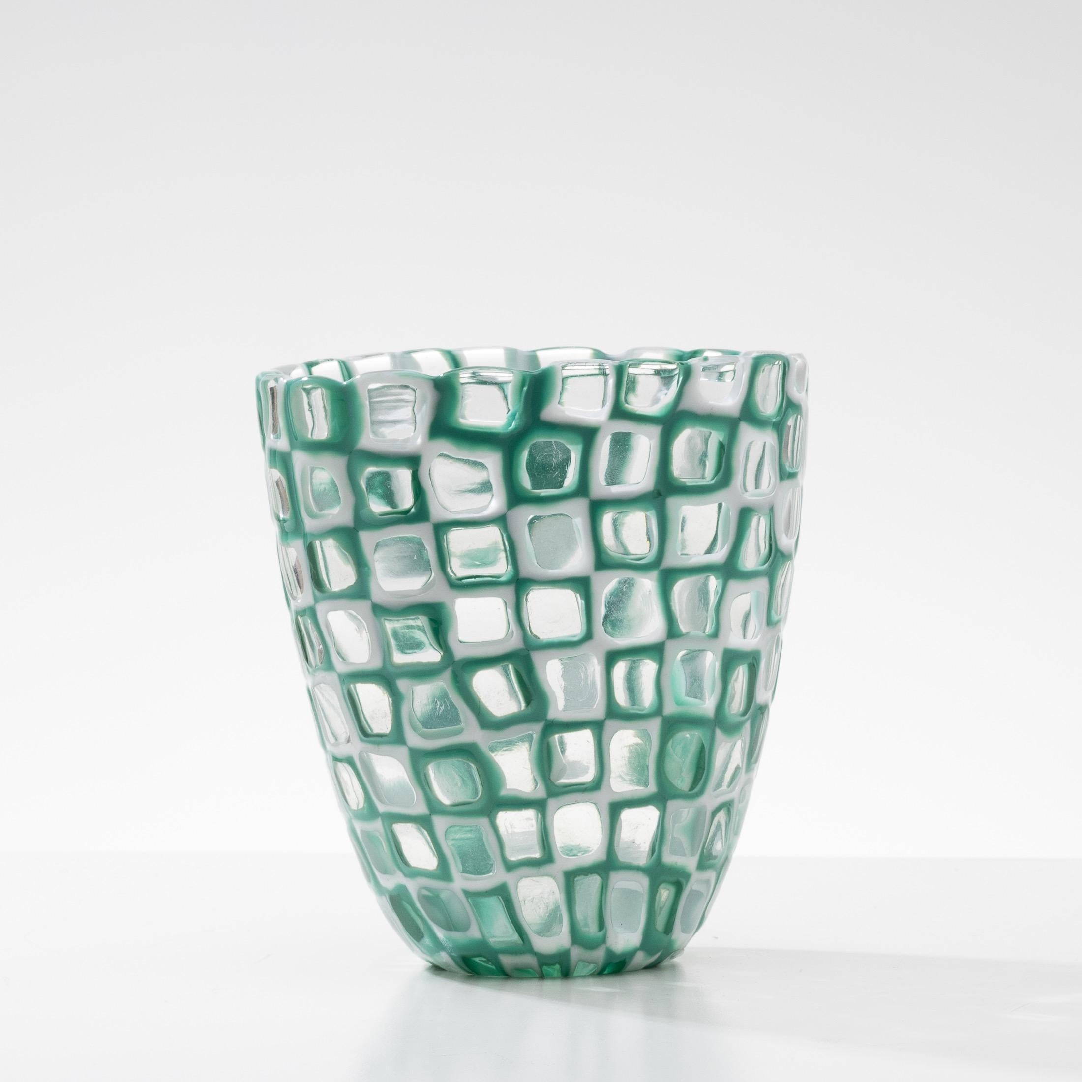 Occhi vase (model referenced under number 8524)
Occhi vase of oval shape on the top.
Composed of an arrangement of latimo glass murrines in the center of clear glass and green and clear glass murrines.
 
