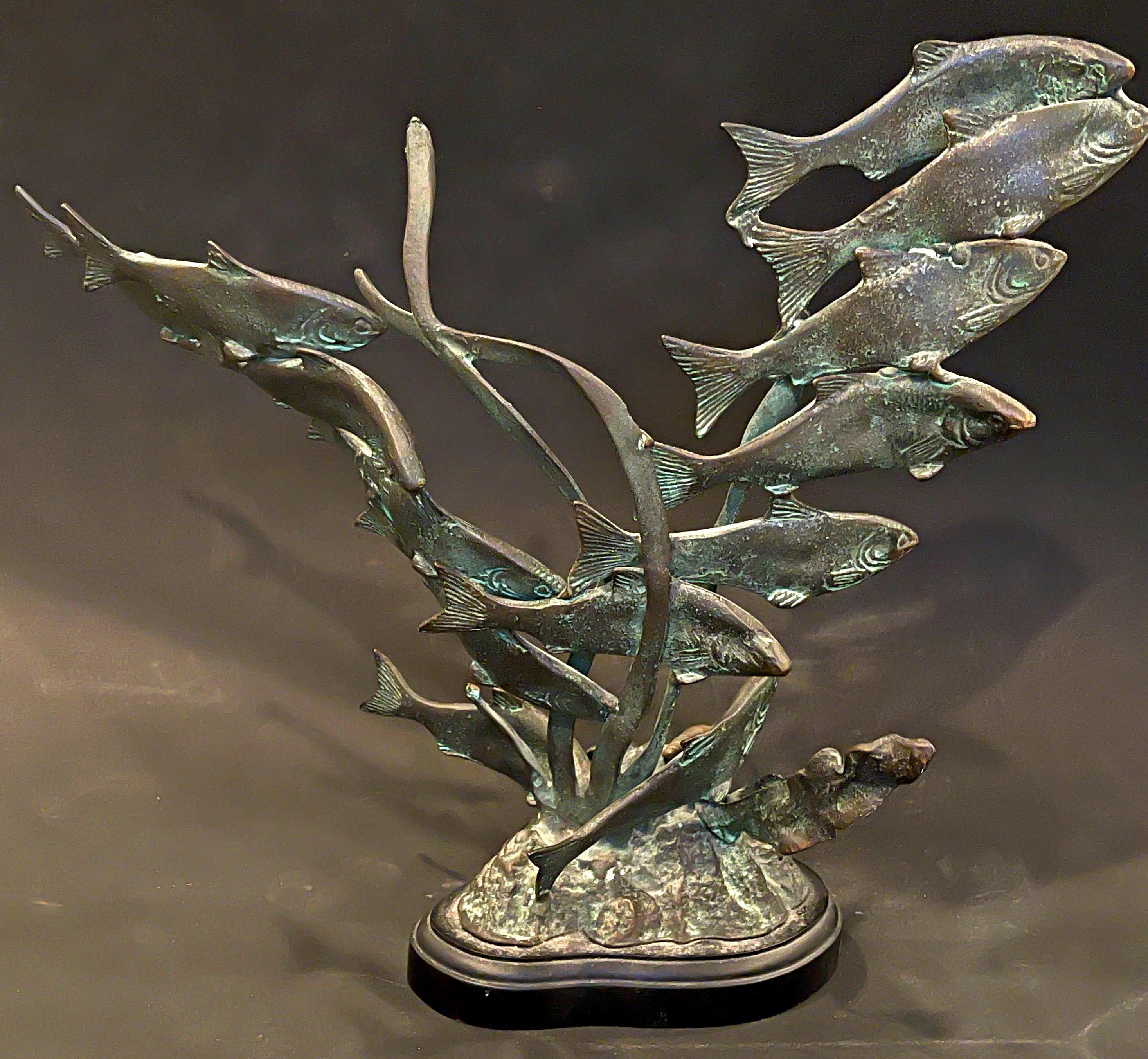 Charming and lively, this rare bronze sculpture depicts a school of fish, undulating in the ocean current, intermixed with seaweed rising from the sea floor littered with seashells, all finished in a lovely classic bronze patina highlighted in green