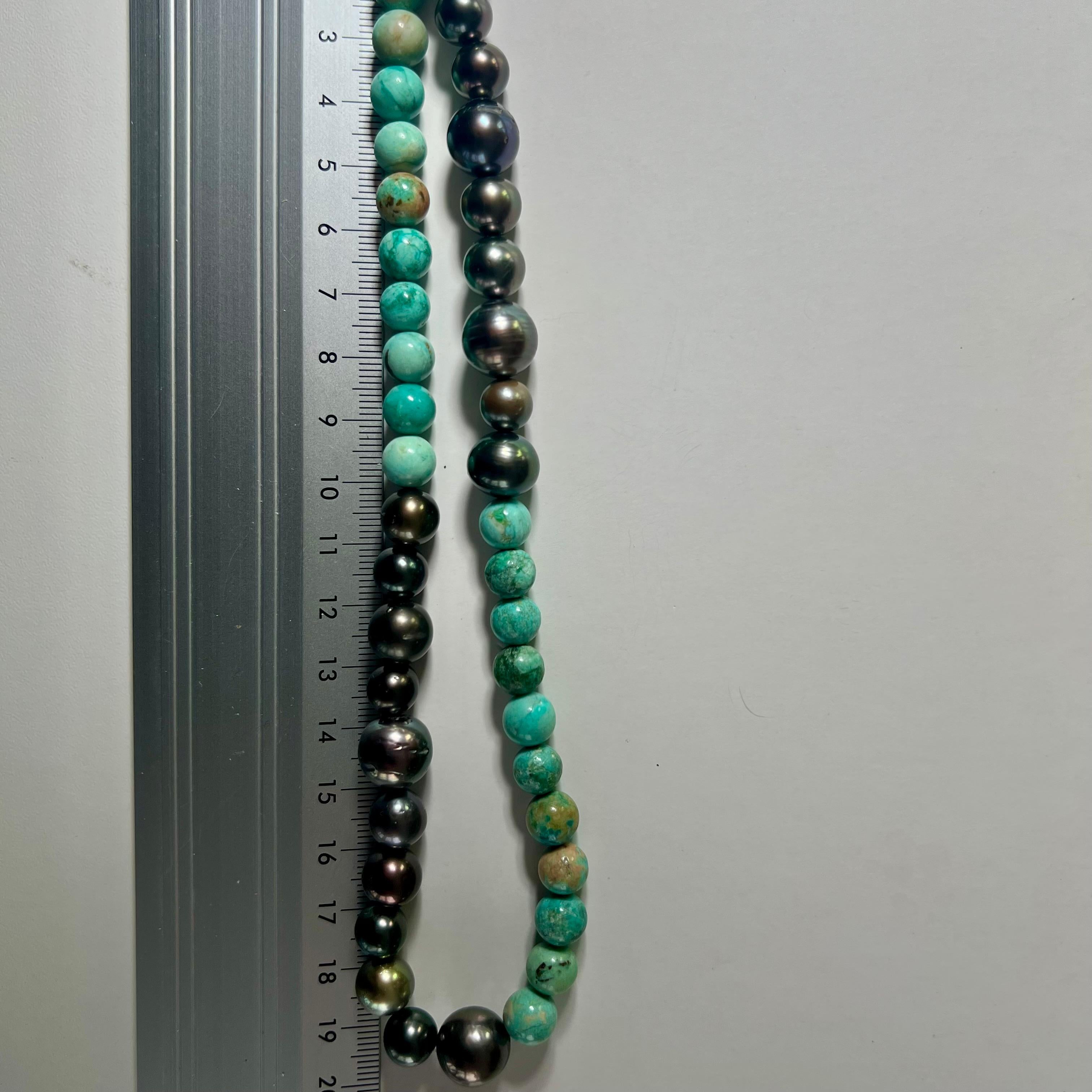 Sumérgete en una audaz sofisticación con este llamativo collar de 40 cm, que incluye vibrantes cuentas de turquesa de Perú de 8 mm combinadas con luminosas perlas de Tahití de 9-11 mm. Un cierre de plata ennegrecida, delicadamente espolvoreado con