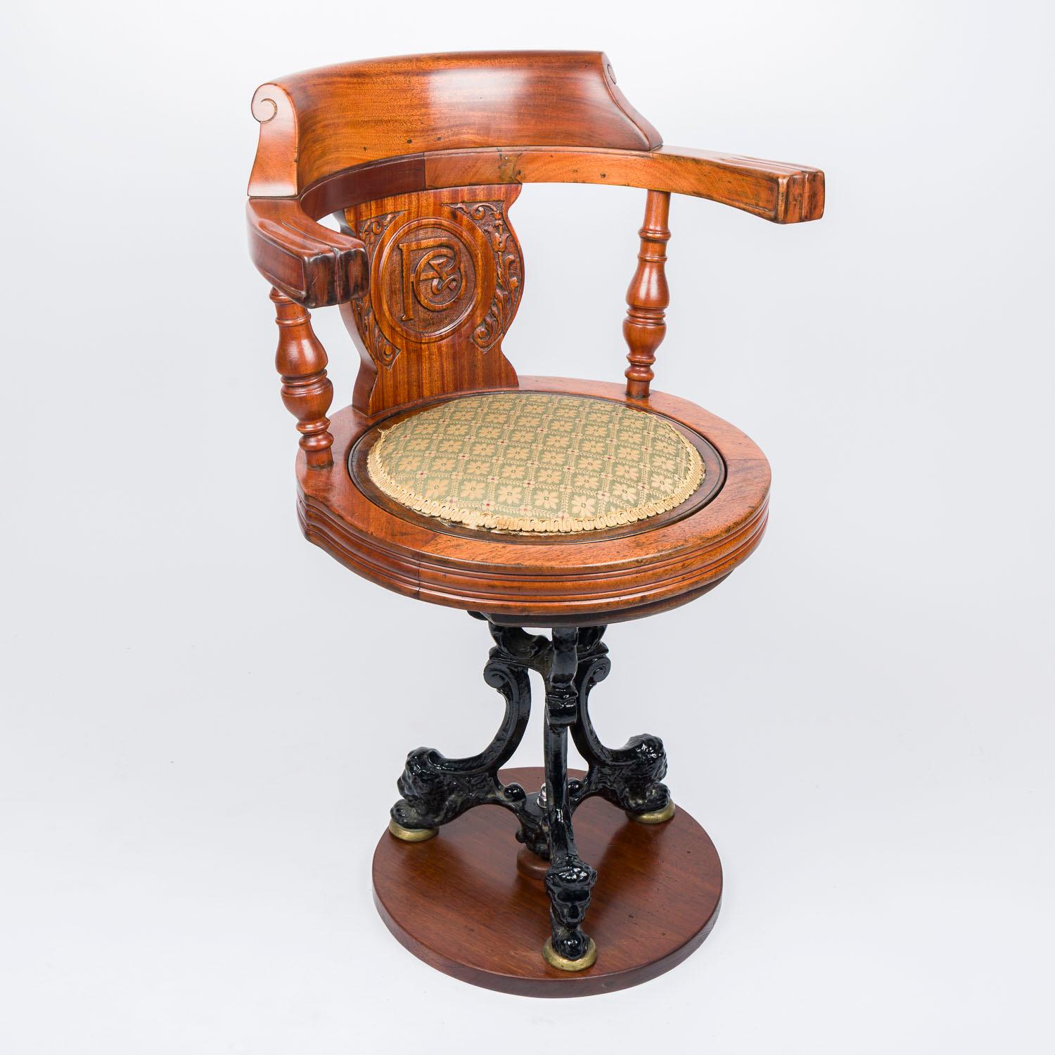 A teak and cast iron revolving ocean liner saloon chair for P & O, circa 1900. 

The chair's back is carved with the P & O shipping company symbol (The Peninsular and Oriental Steam Navigation Company).

Cast iron tripod base with Lion's heads.