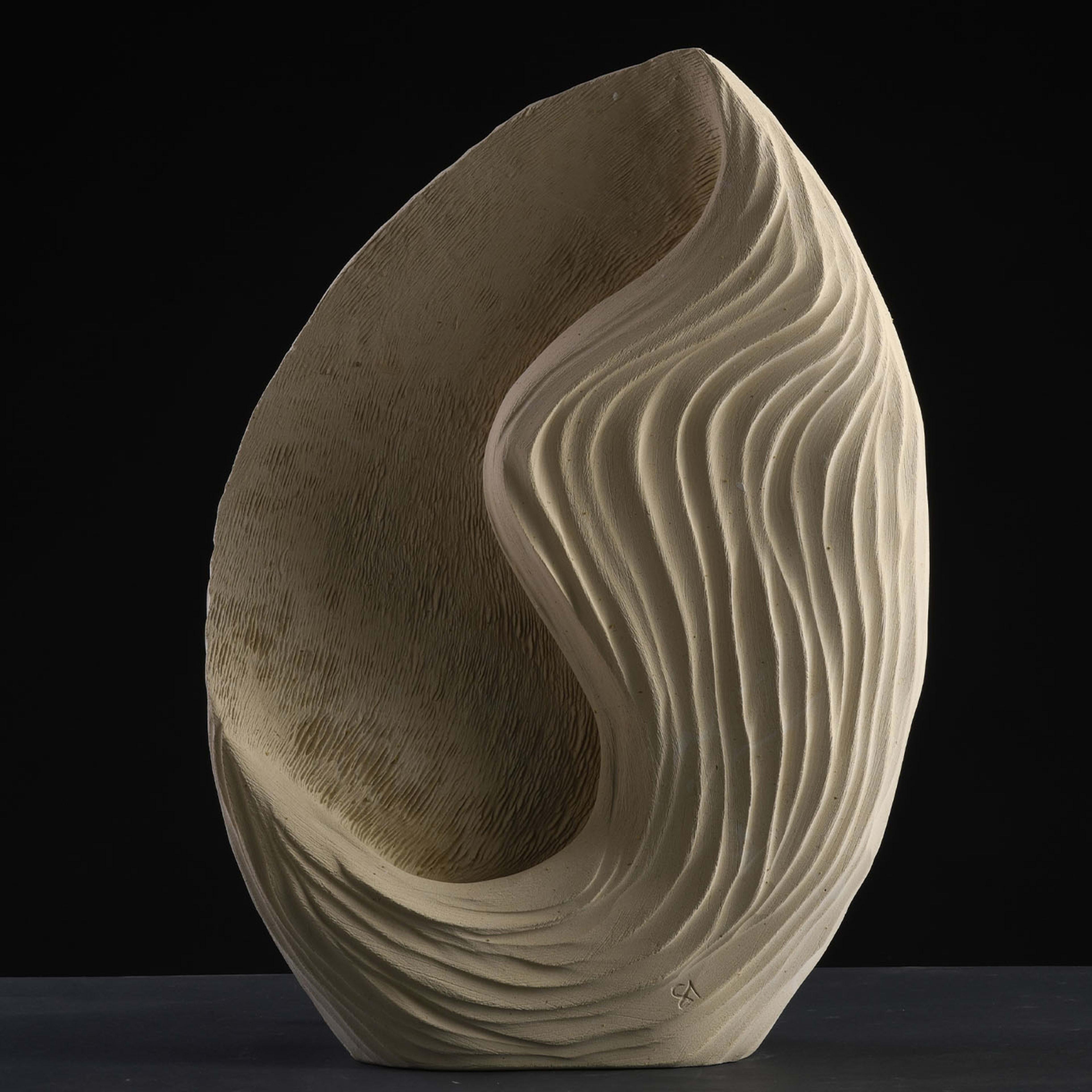 Inspired by the wind rippling the ocean's surface, pleats where light seeps in mark this singular luminous sculpture. A special marine-origin stone rich in fossils that can only be quarried near Lecce, Apulia is the one artist Andrea Serra selects