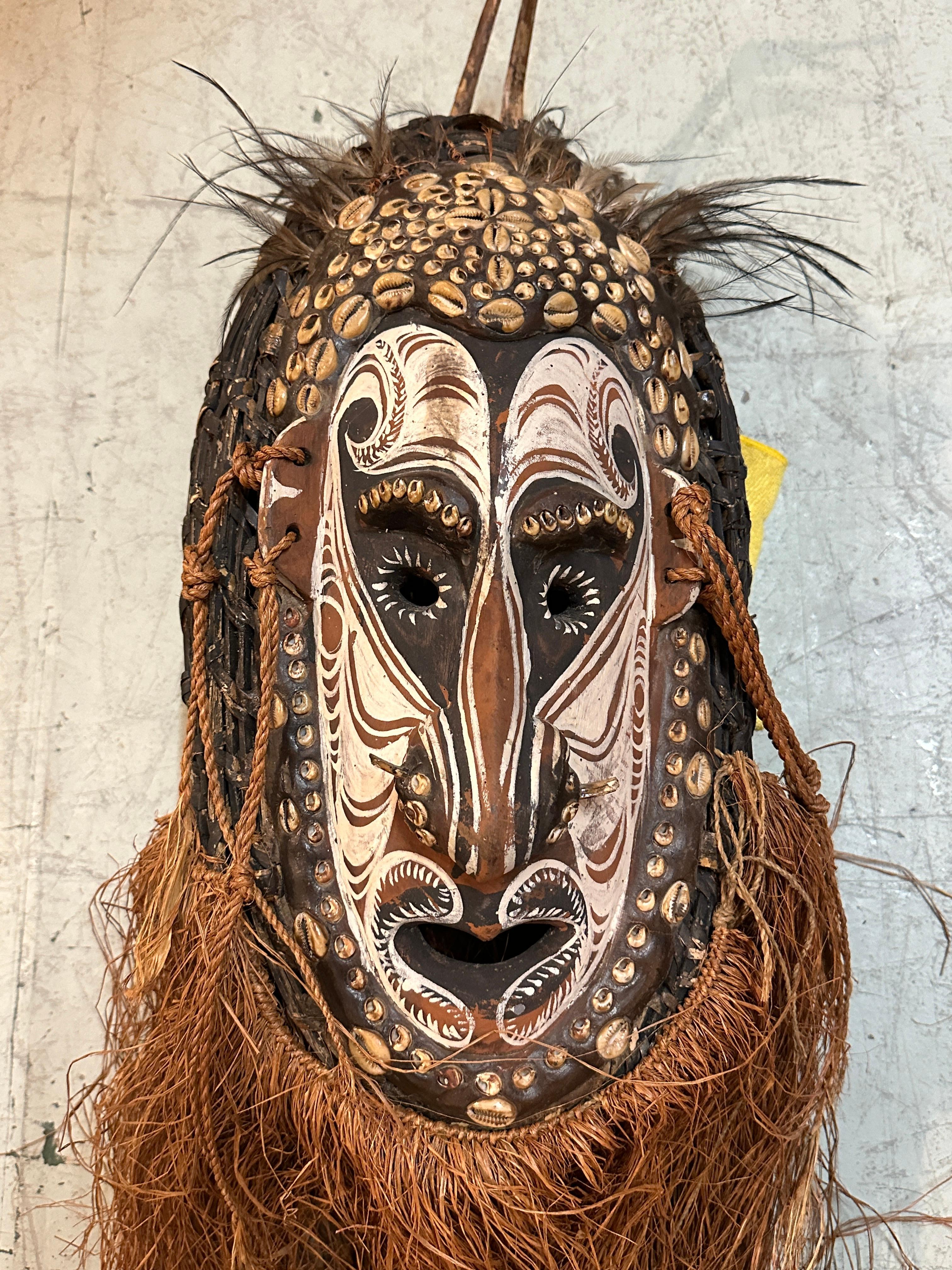 Masque de cérémonie de la région du fleuve Sepik, en Papouasie-Nouvelle-Guinée, associé aux traditions de danse des Eastern Highlands. Fabriqué à partir de bois, de cauris, d'argile, de pigments et de fibres végétales, il reflète les qualités