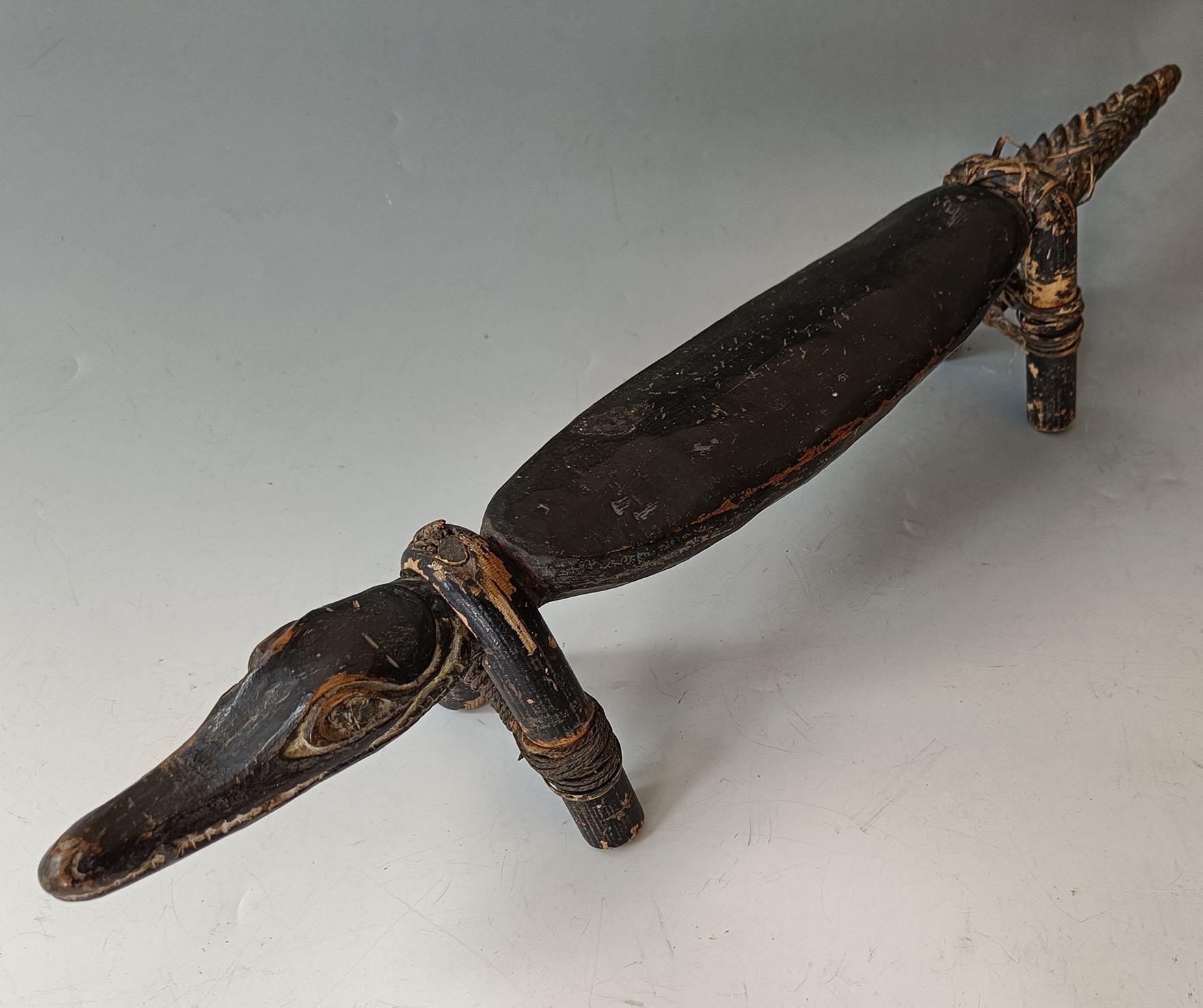  Un superbe appui-tête en crocodile sculpté et peint de la région de Sepik en Papouasie-Nouvelle-Guinée.

Le site  Image de crocodile finement sculptée en forme linéaire avec une queue dentelée et des Diptych Fine Arts, le crocodile est révéré et