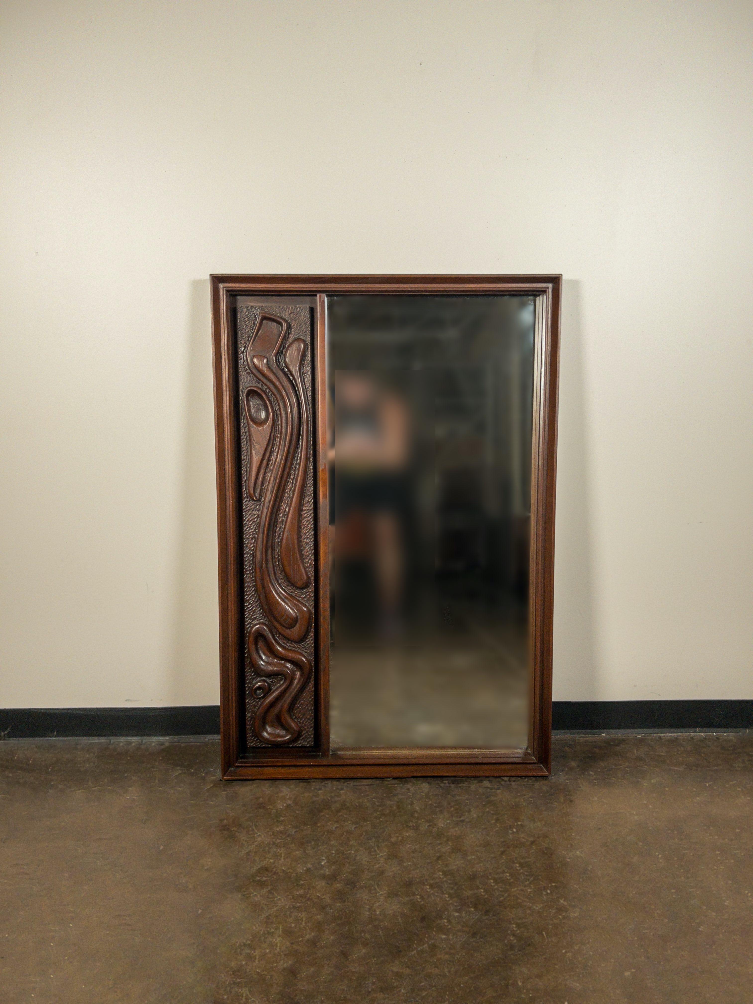This fantastic lacquered sculpted walnut 'Oceanic' wall mirror by Pulaski Furniture Corporation, circa 1969 which perfectly encapsulates the California surf mentality of the 1960s and 1970s, making this piece a highly sought after design by Tiki