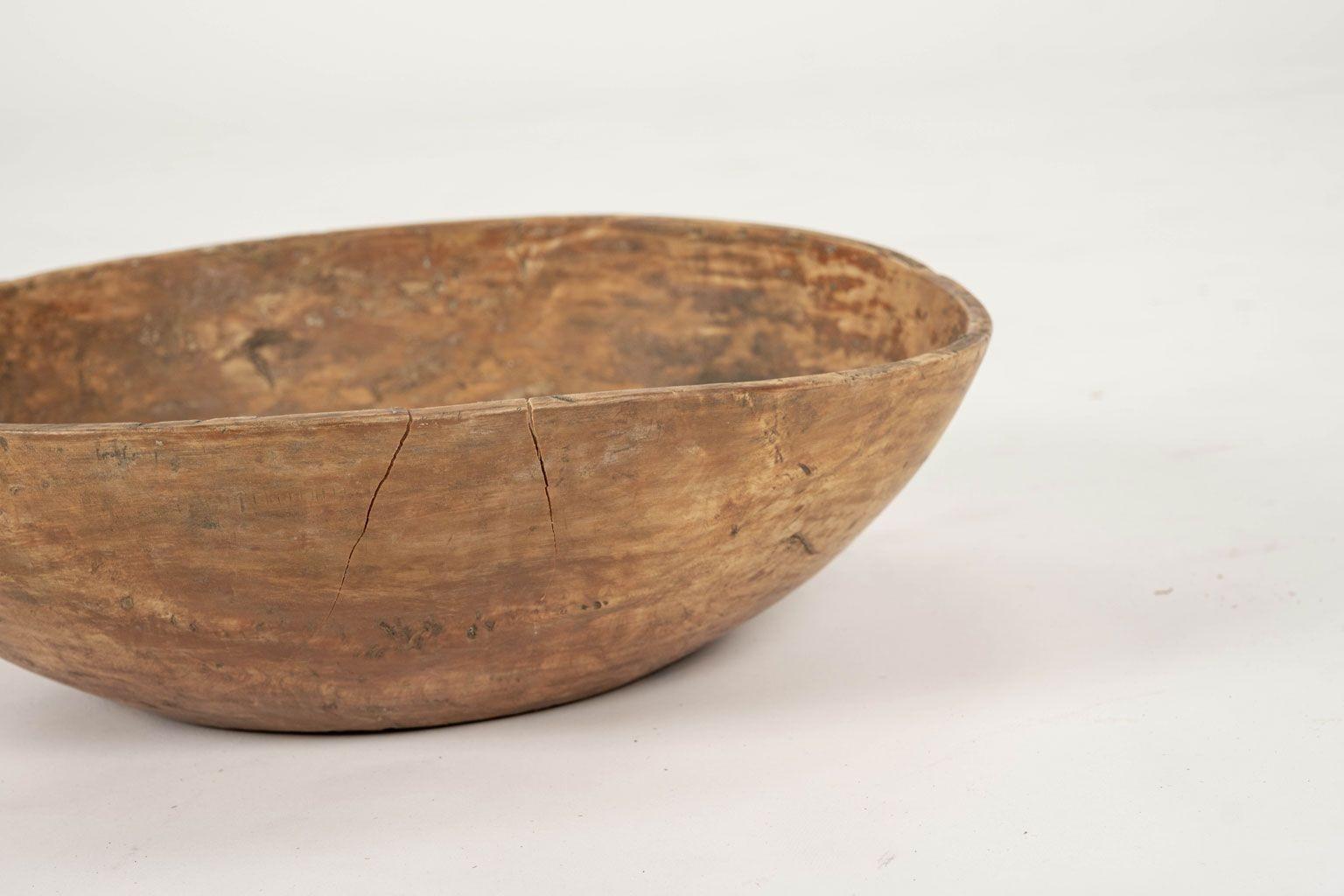 Ocher color rustic Swedish wooden dug out bowl dating to 19th century. Wood plug repair and remnants of early paint.

Note: When shipped, antique wood may shrink and/or split along its grain, and veneer may loosen or peel, due to changes in humidity