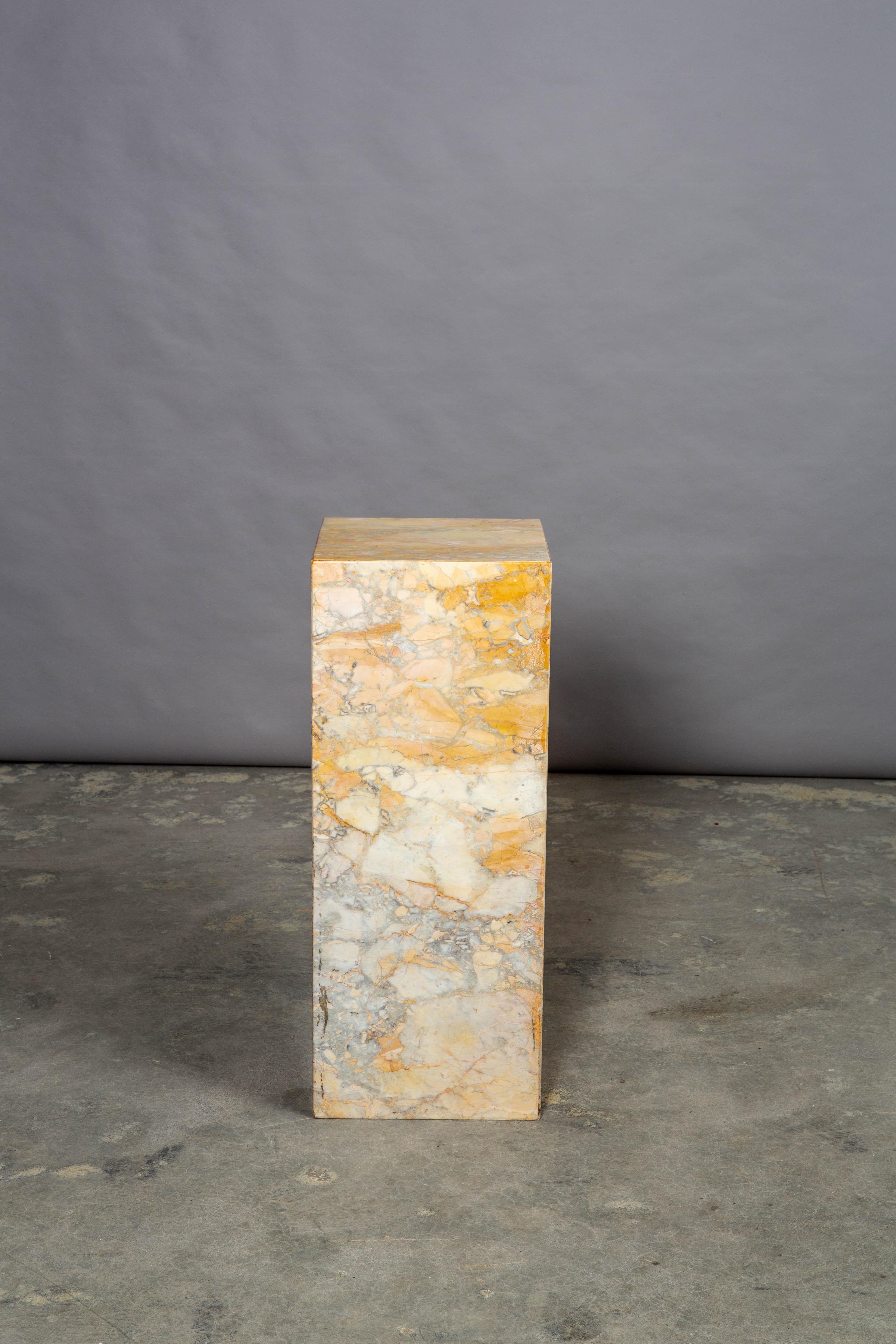 Mid-Century Modern Italian marble pedestal. Heavy and in very good condition, this pedestal has great color variation ranging from ochre to grey with great shades of tan and light browns. Very minor losses to the top edge but consistent with age.