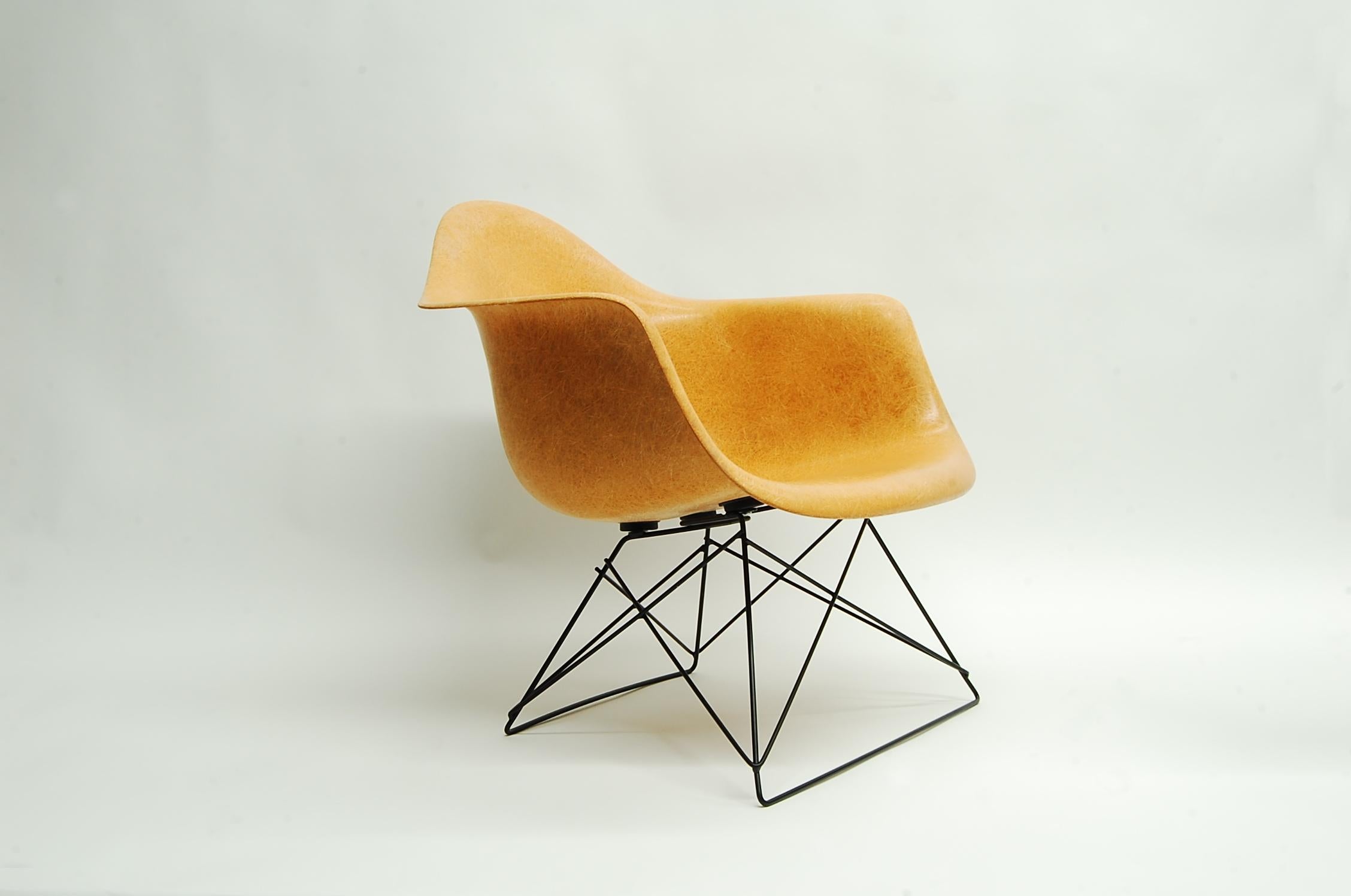 Ochre Eames armshell chair, produced by Herman Miller, circa 1960s-1970s, on black 'cats cradle' base. Armshell has great fiber content, and is Summit production (Circle 