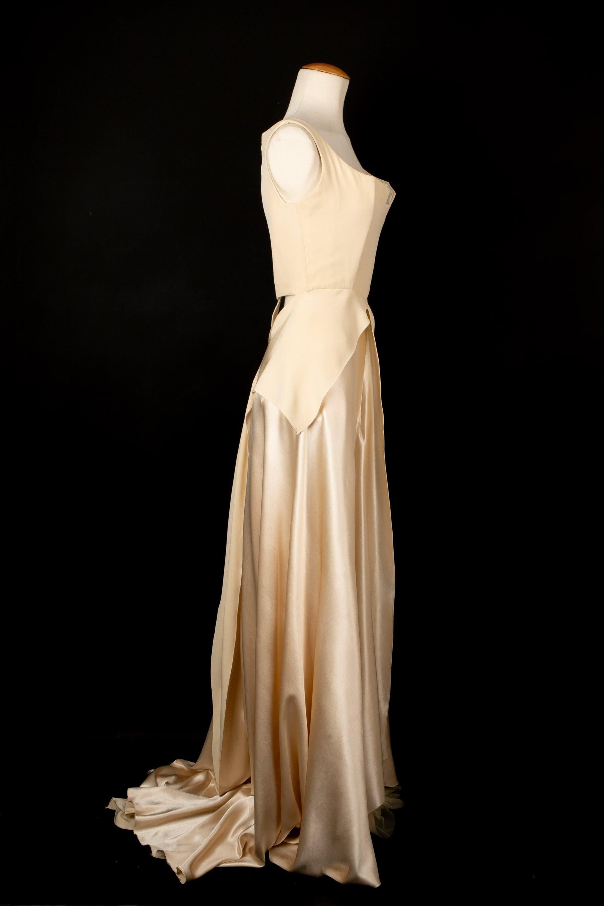 Ocimar Versolato - Long off-white satin evening dress with an openwork back and a hang skirt. No size indicated, it fits a 36FR. To be mentioned, some marks on the satin of the dress bottom.

Additional information:
Condition: Good