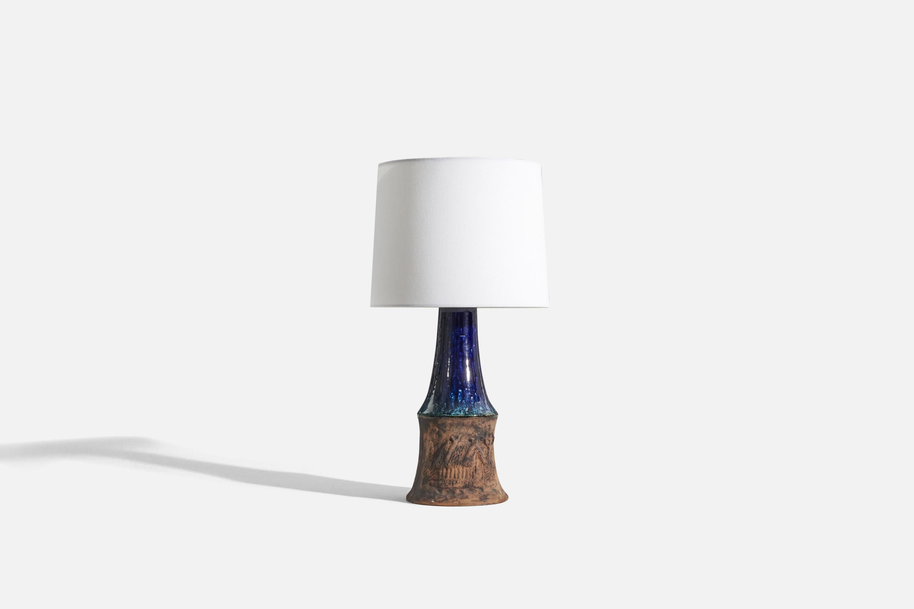 A brown and blue-glazed stoneware table lamp designed by Öcsi Homoki (1935-2017) and produced by Munkavalvet Keramik Visby, Gotland, Sweden, late 1960s. 

Sold without lampshade. 
Dimensions of Lamp (inches) : 14.4375 x 5.6875 x 5.6875(H x W x
