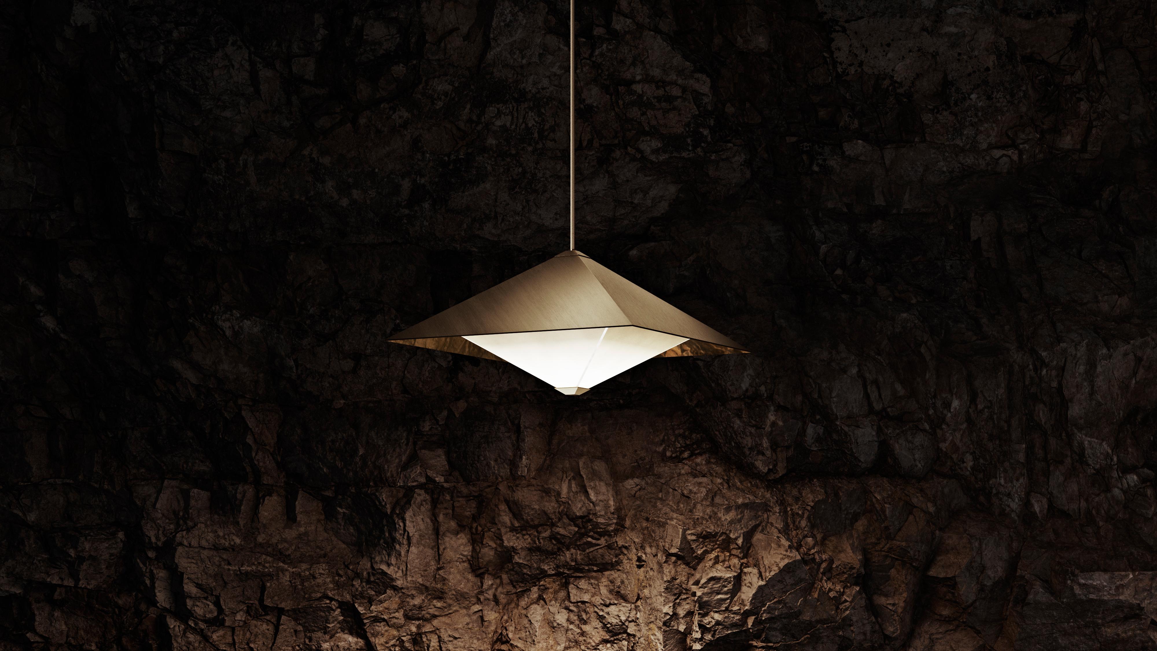 OCTA’s pendant originates from the intersection of two octahedral shapes. A brass shade and a frosted diffuser. The latter floats below the mirrored surfaces of the shade; shapes are reflected and multiplied, displaying a unique optical