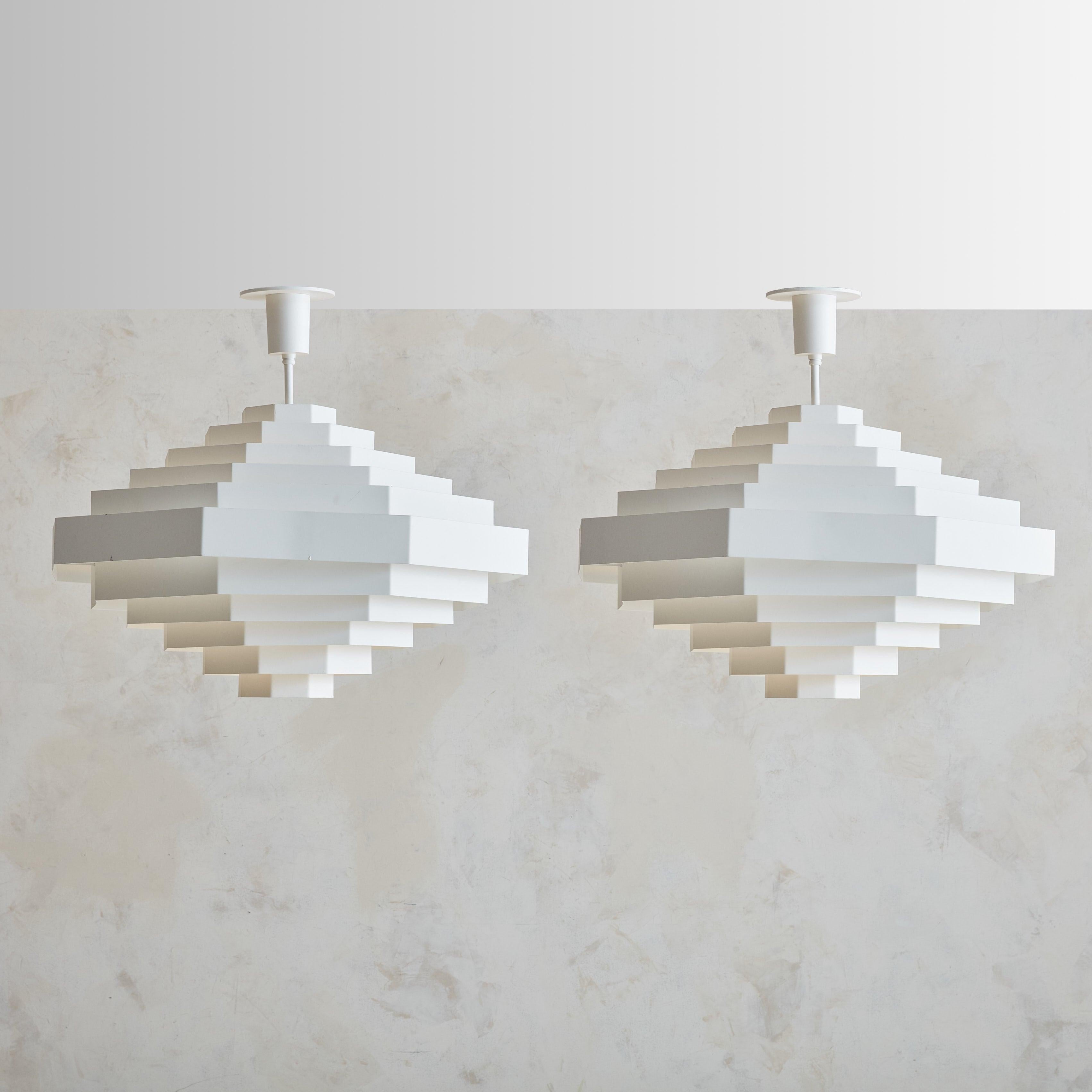 A rare  of model ‘Octaform’ pendant lights, designed by Spectral in Freiburg, Germany, in the 1960s. Each pendant features stacked, angular layers of metal that form a stepped, diamond-like silhouette, allowing light to be dispersed into radiating
