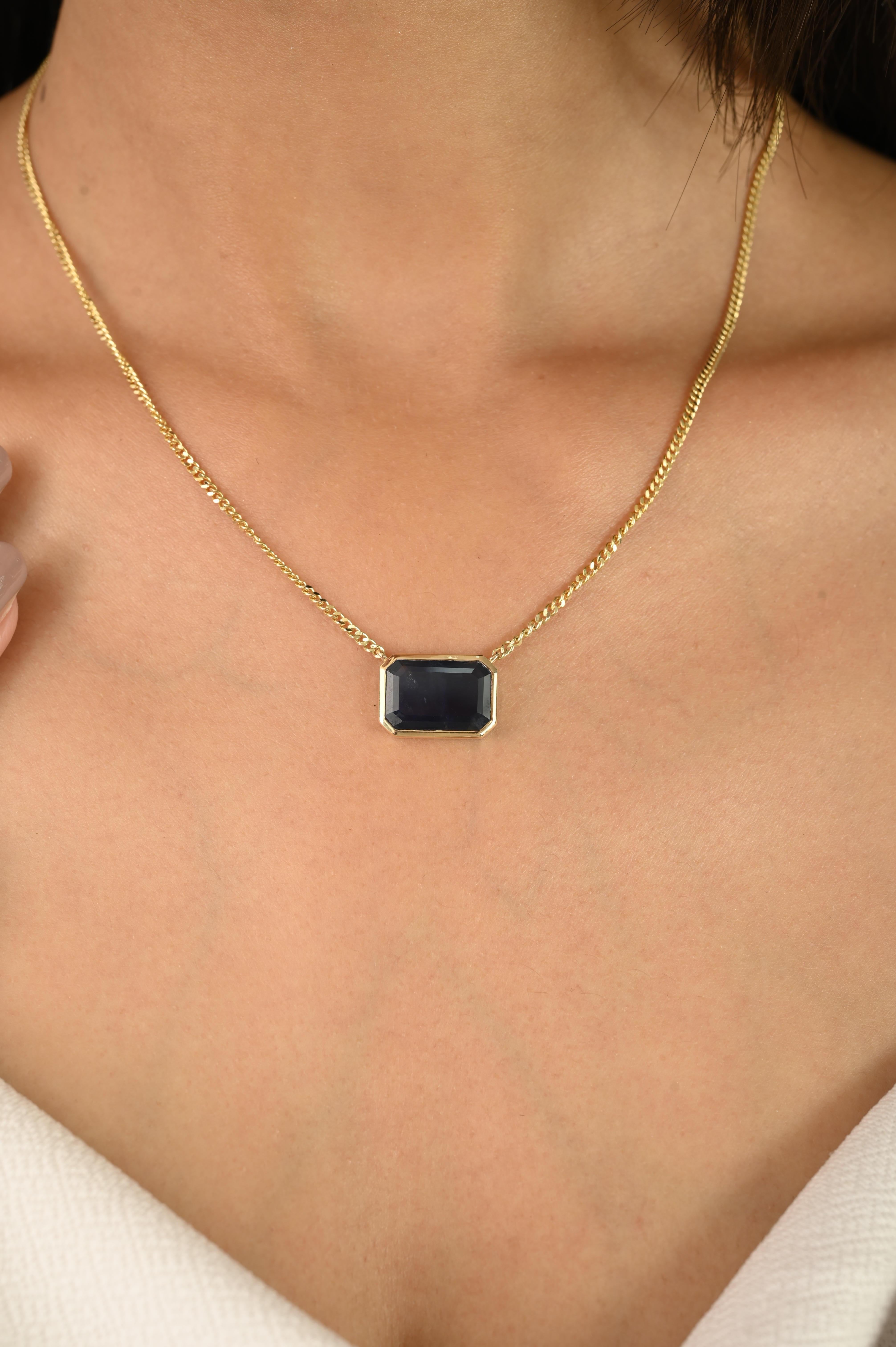 Rehaussez votre collection de bijoux avec ce collier saisissant, conçu en or jaune 14k lumineux et mettant en valeur une pierre précieuse d'un bleu profond de 4,46 carats. La pierre centrale de taille émeraude est sertie dans une élégante monture