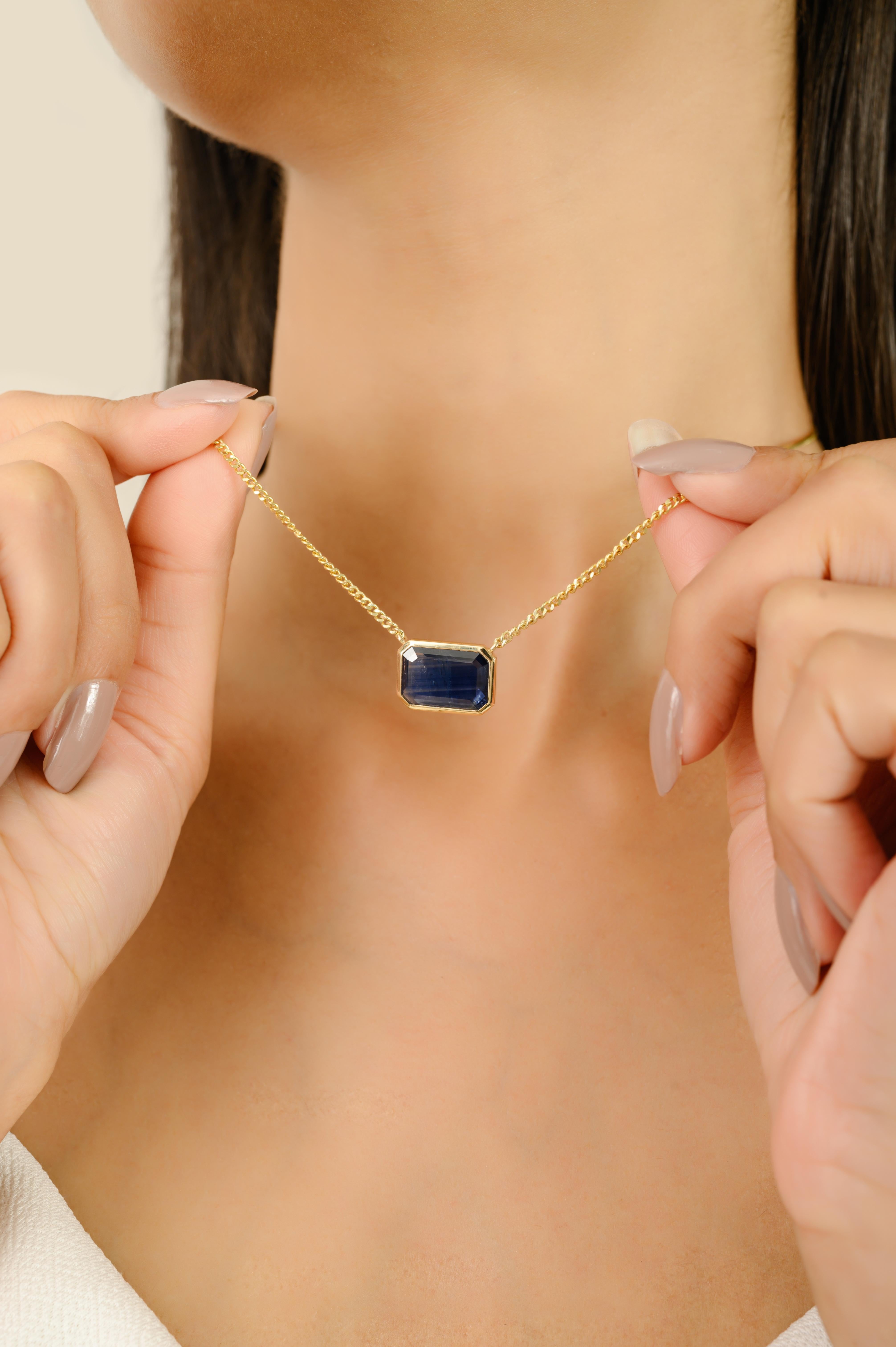 Rehaussez votre collection de bijoux avec ce collier saisissant, conçu en or jaune 14k lumineux et mettant en valeur une pierre précieuse d'un bleu profond de 4,46 carats. La pierre centrale de taille émeraude est sertie dans une élégante monture