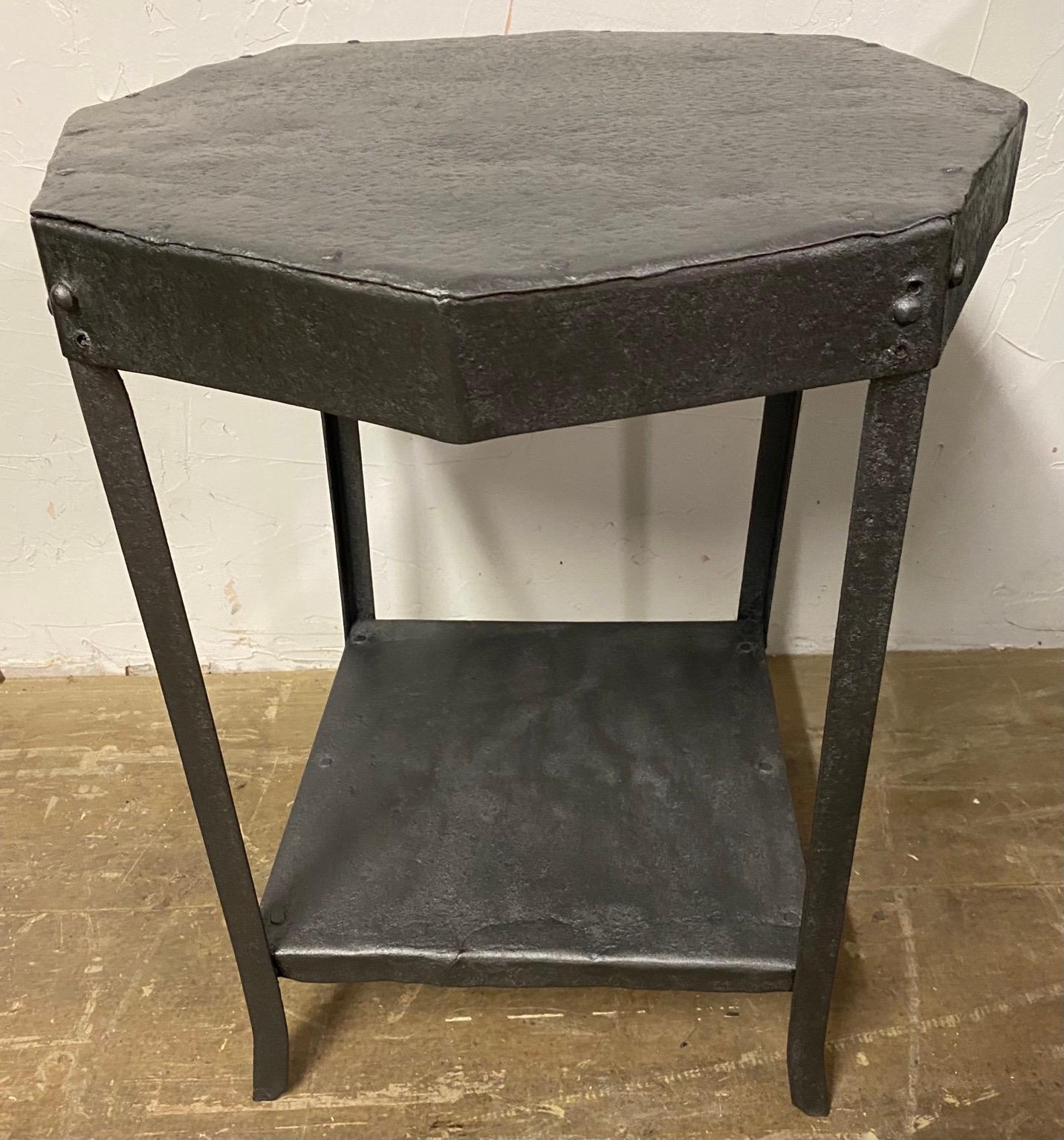 Industrial rustic French iron tables with beautiful patina on the metal. Table exhibits rustic charm and beauty. Can be used indoors as side tables or outdoors as garden table. Table has an octagon top and features shelf at the base serving to tie