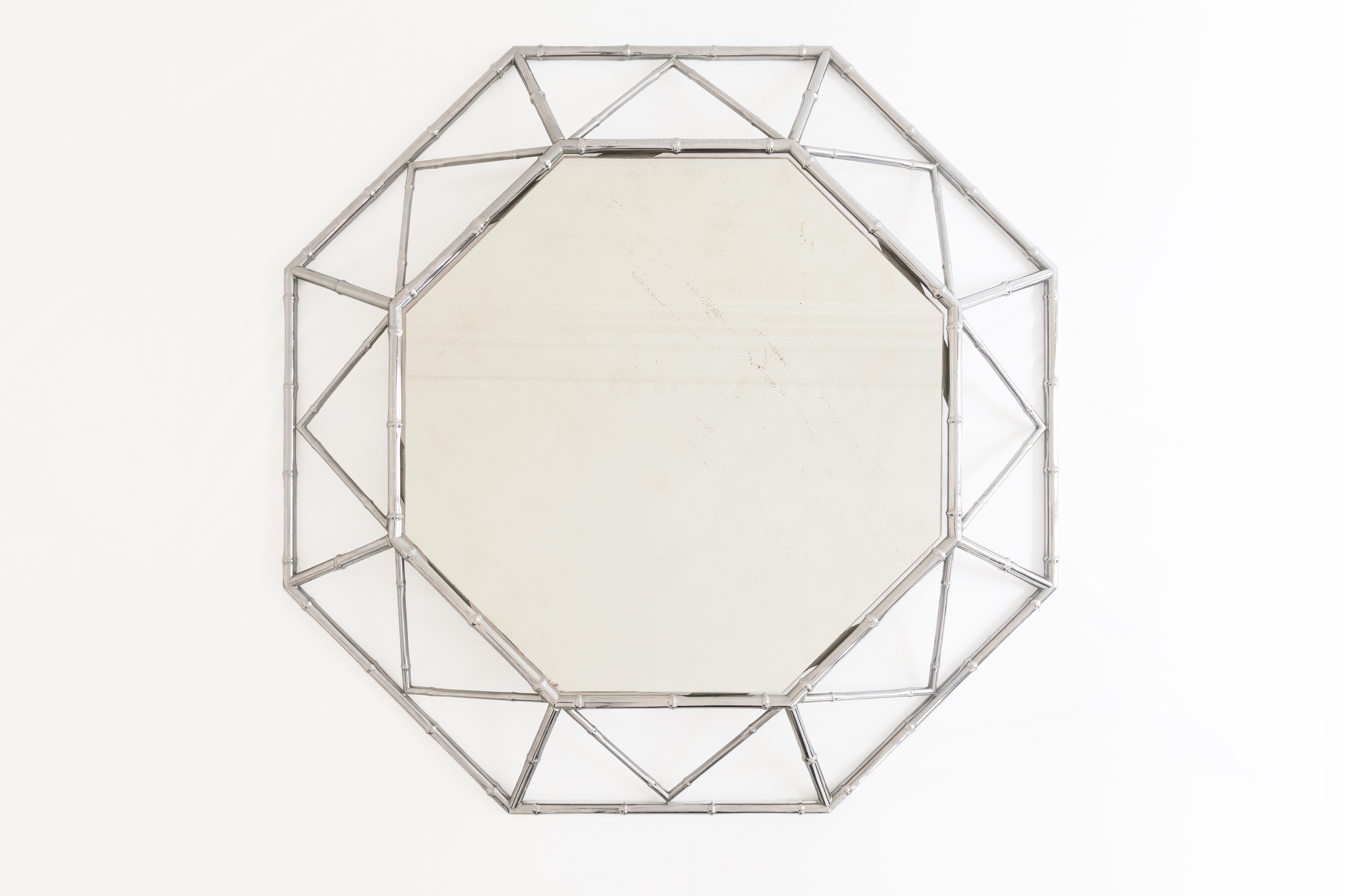 Ce miroir octogonal des années 1980 transcende l'ordinaire grâce au contraste harmonieux entre le bambou organique et le cadre métallique épuré qui crée une déclaration équilibrée mais audacieuse, évoquant à la fois l'originalité et la