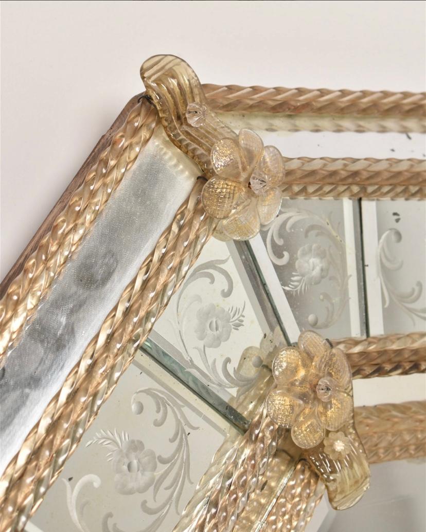 An attractive mirror from the Isle of Murano, this Venetian glass mirror has attractive braided glass rods, florettes and a pleasing etched design to the mirror. 24 karat gold inclusion gives a nice shimmer. In pretty good antique condition. We note