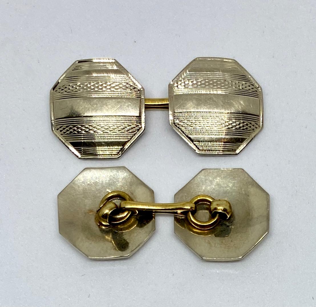 Double-sided, machine-engraved cufflinks in 14K white gold with 14K yellow gold connectors. 

The four octagonal faces measure 13.6mm across; together the cufflinks weigh over 6.5 grams. 

The cufflinks are unmarked but based on details and