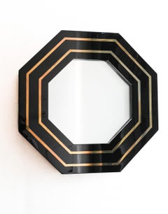 Miroir mural octogonal en laque noire et laiton, attribué à Jean Claude Mahey