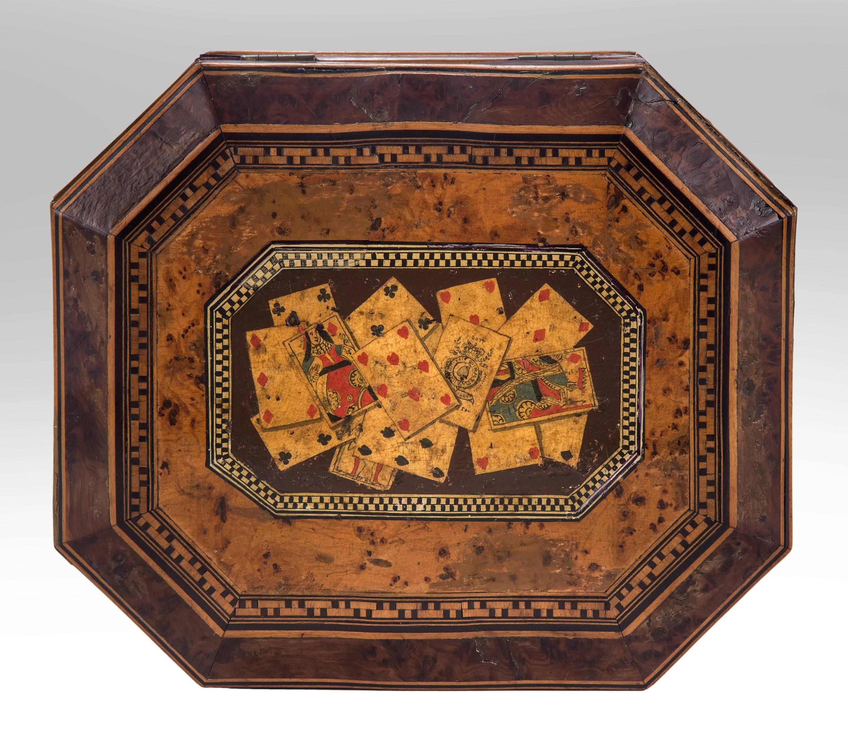 Octagonal box with playing cards
19th century
A charming box with delightful playing card motif adorning the lid. Of octagonal shape, the burl wood top with parquetry boarders centring a selection of playing cards, the conforming burl wood box