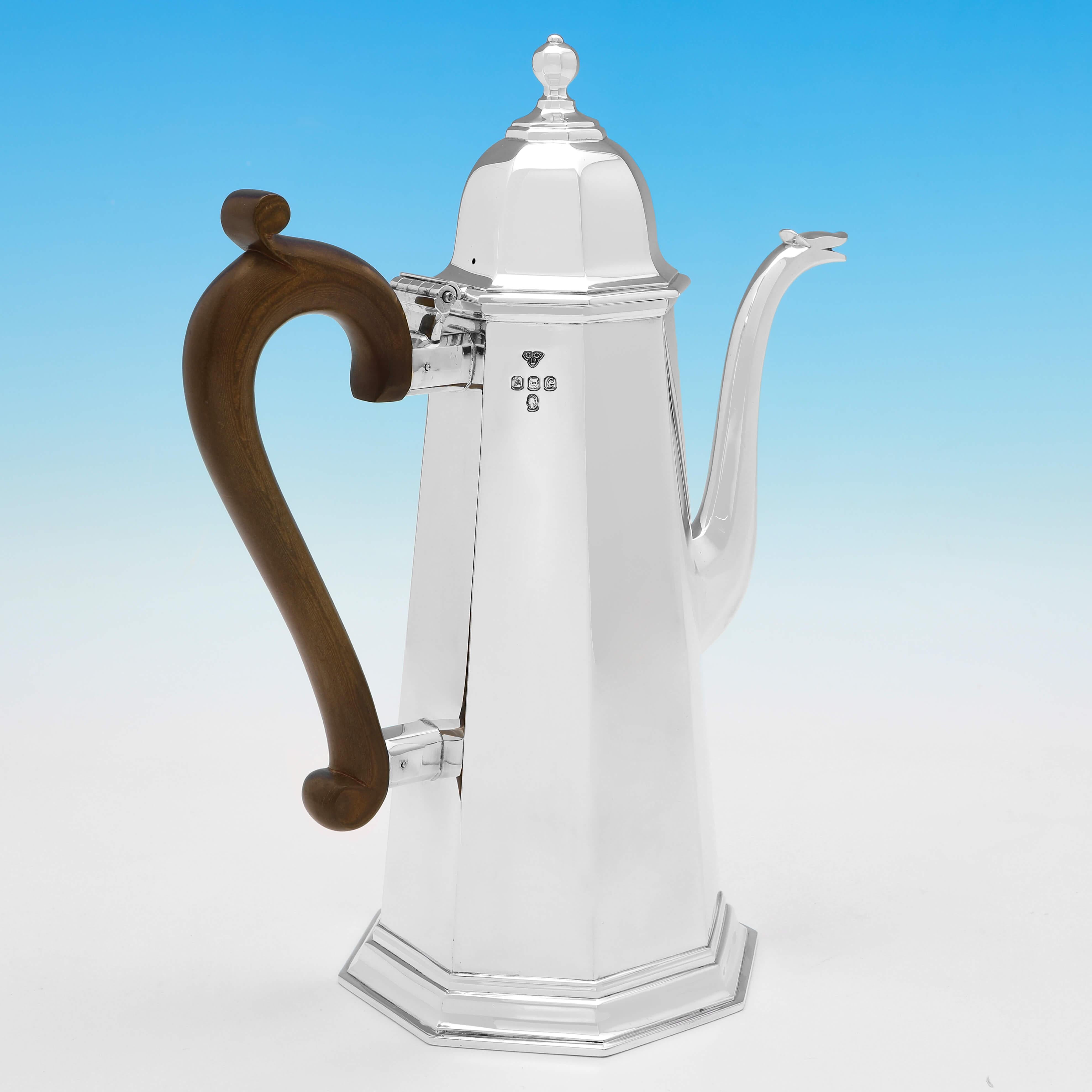 Hallmarked in London, 1977 by Garrard & Co., this Britannia Standard Silver Coffee Pot is in excellent condition. This magnificent coffee pot is octagonal in shape with a serpent spout and a fruitwood handle. 

It measures 11