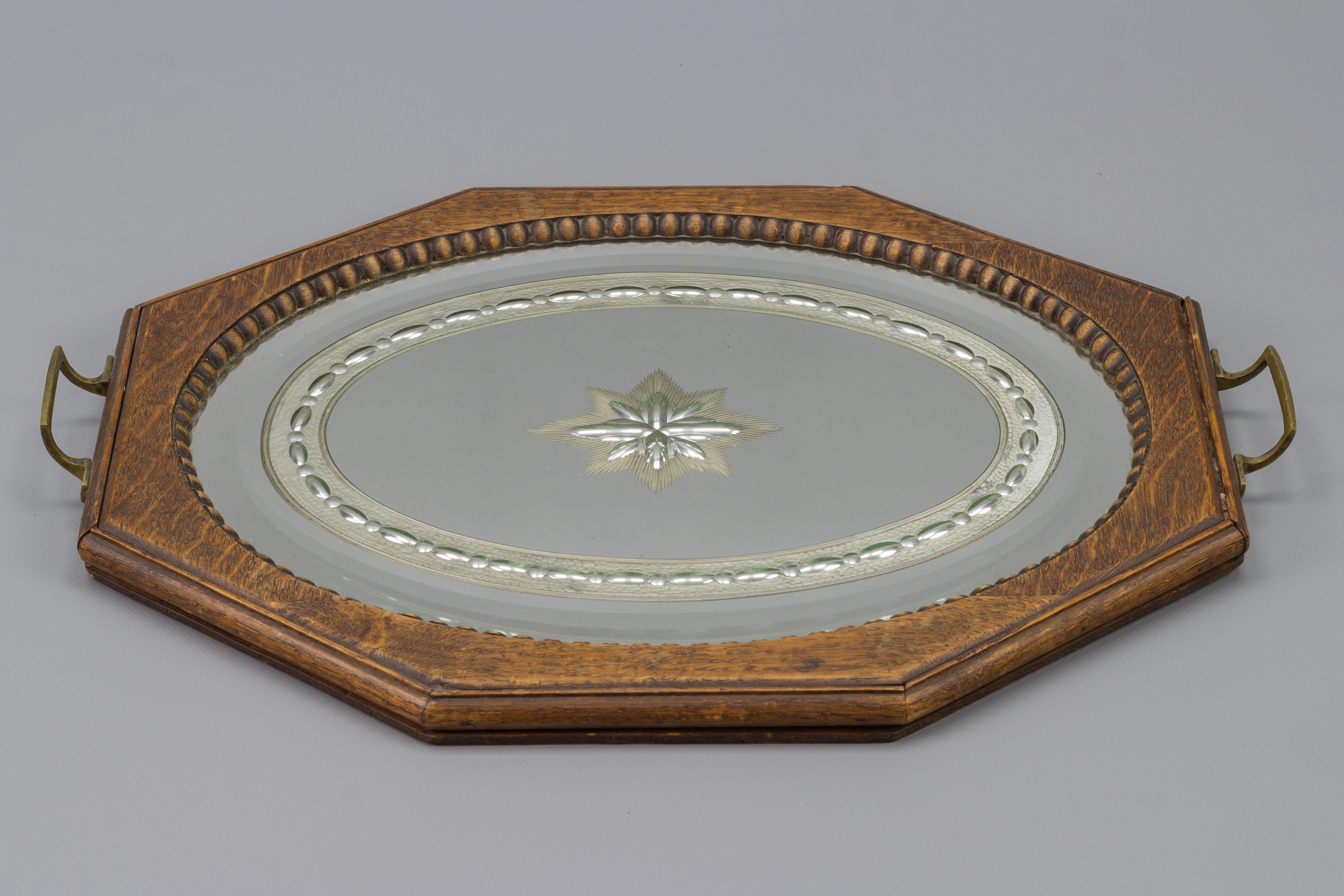 Vintage octagonal brown wood serving tray with oval etched mirror base and brass handles. Europe, the 1950s.
Dimensions: Height: 4 cm / 1.57 in; width: 33 cm / 12.99 in; length: 47 cm / 18.5 in.


