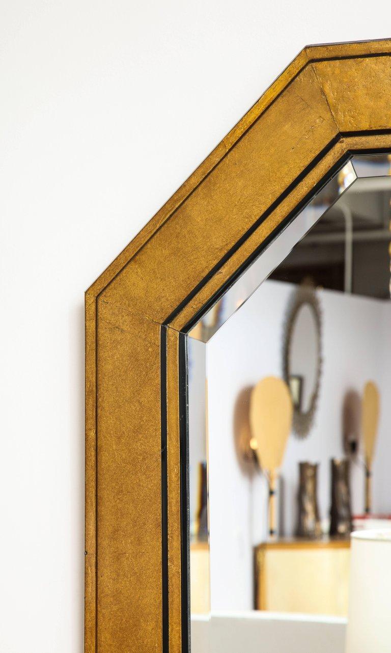 A great gilded octagonal bevelled mirror in the style of Karl Springer in gilt and ebonized frame 50