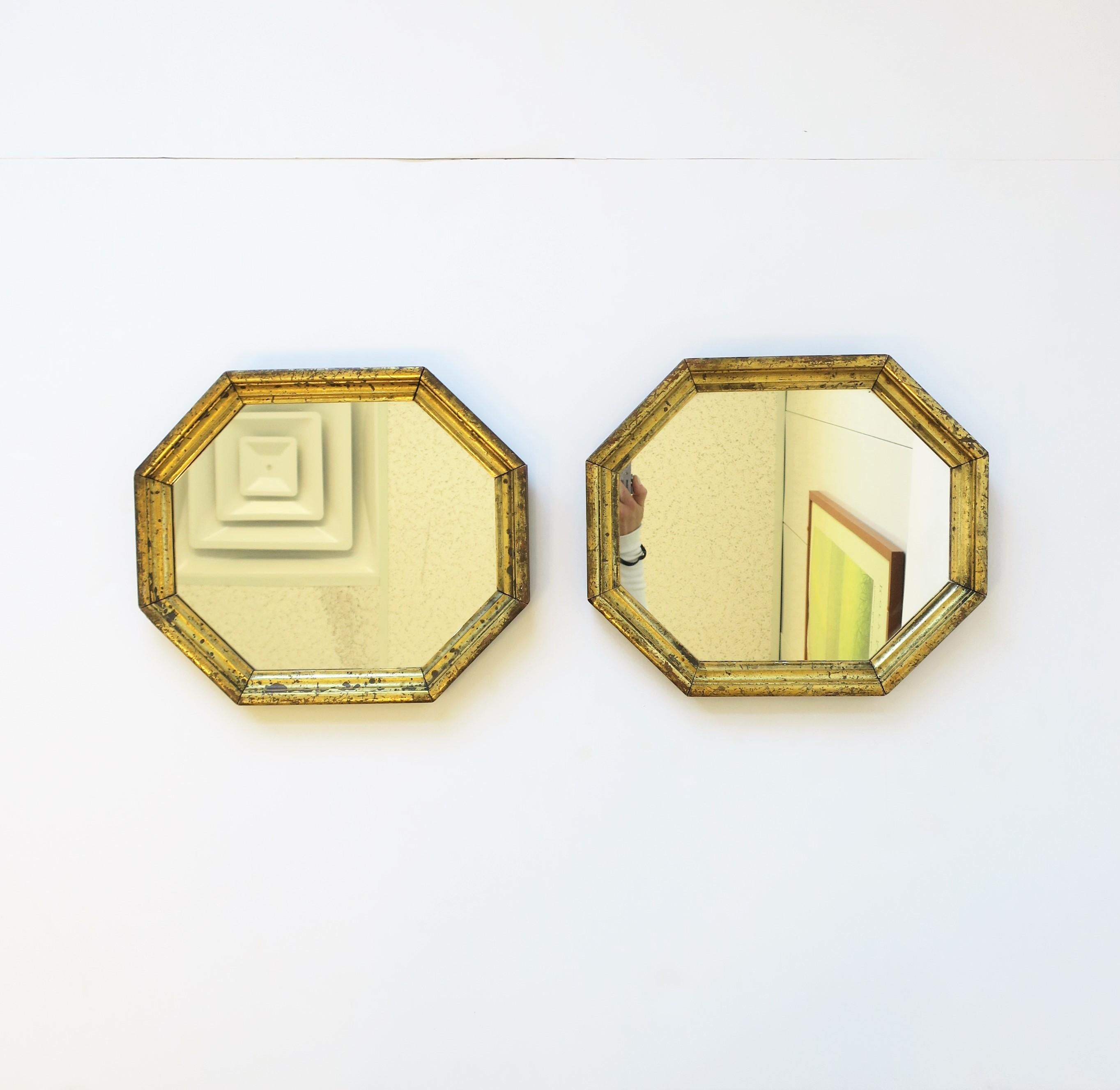 A beautiful pair of octagonal gold giltwood mirrors, circa early 20th century. A hand-crafted pair of mirrors with gold gilt applied to octagonal wood frames. Mirrors can hang horizontally or vertically. As shown on back, mirrors are prepared to