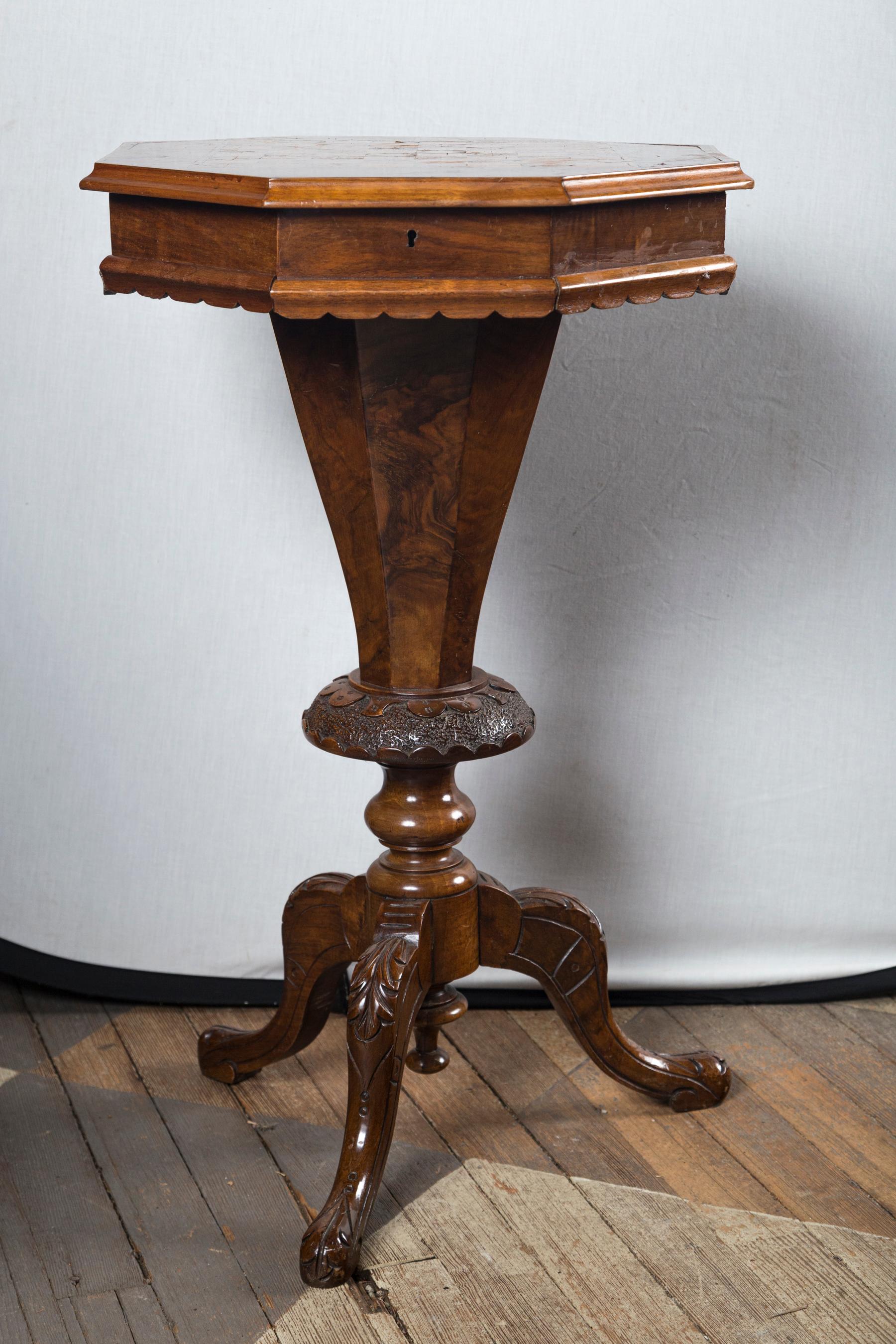 The of walnut, inlaid with a checker board of plain squares, and various woods, with mother of pearl. There are 2 squares of brass.
The top opens to reveal a sewing needs interior of divided sections, and an 11.5 inch deep center well. The dividers