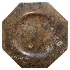 Placa octogonal de mármol con fósiles