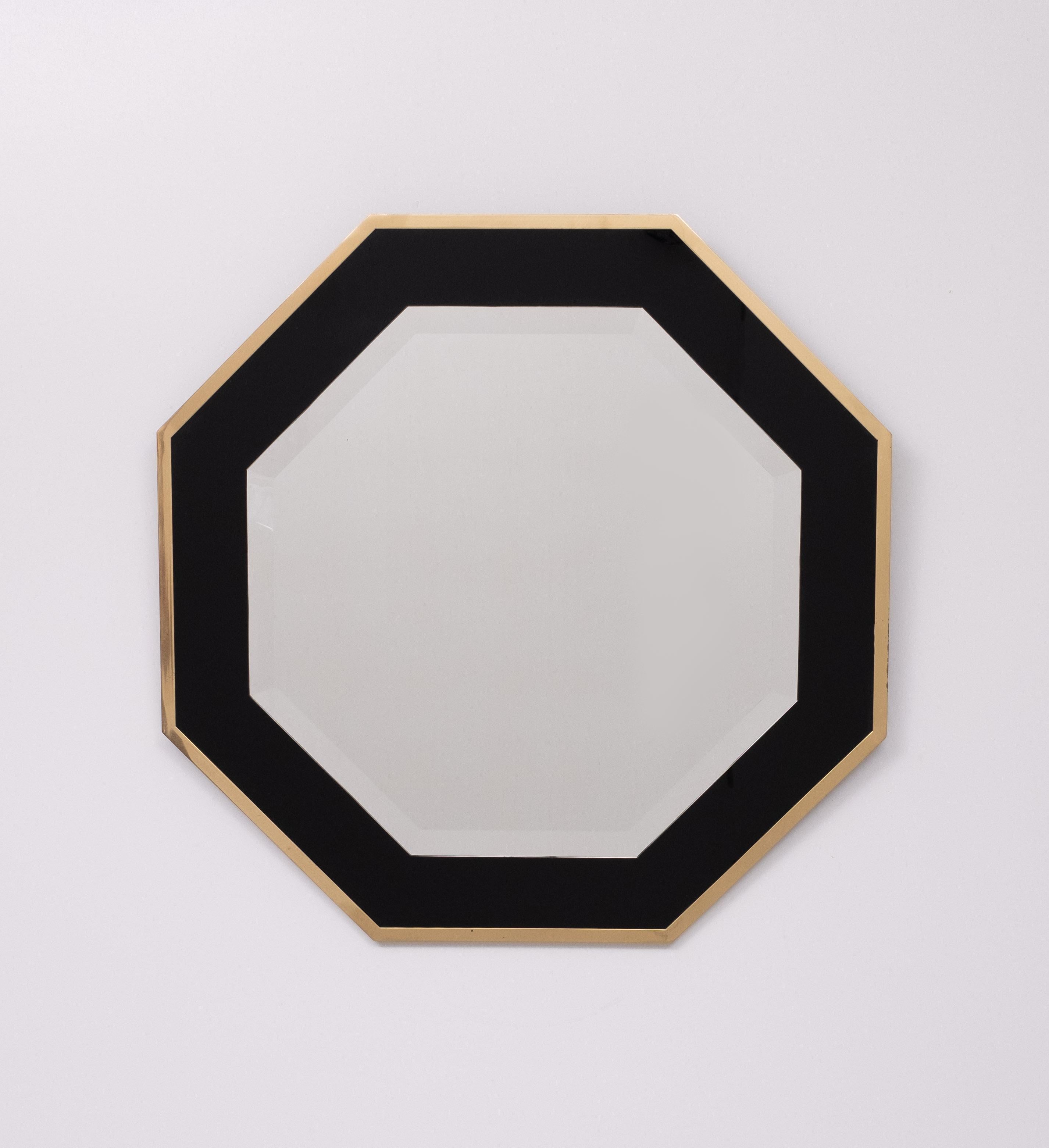 Superbe miroir avec cadre octogonal en laiton sur fond de verre noir.     Miroir biseauté . attribué à Jean Claude Mahey 1970 