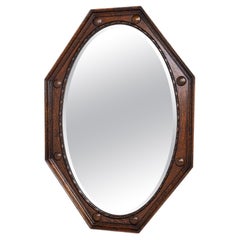 Octagonal mirror in carved oak, made in England, early 20th century.