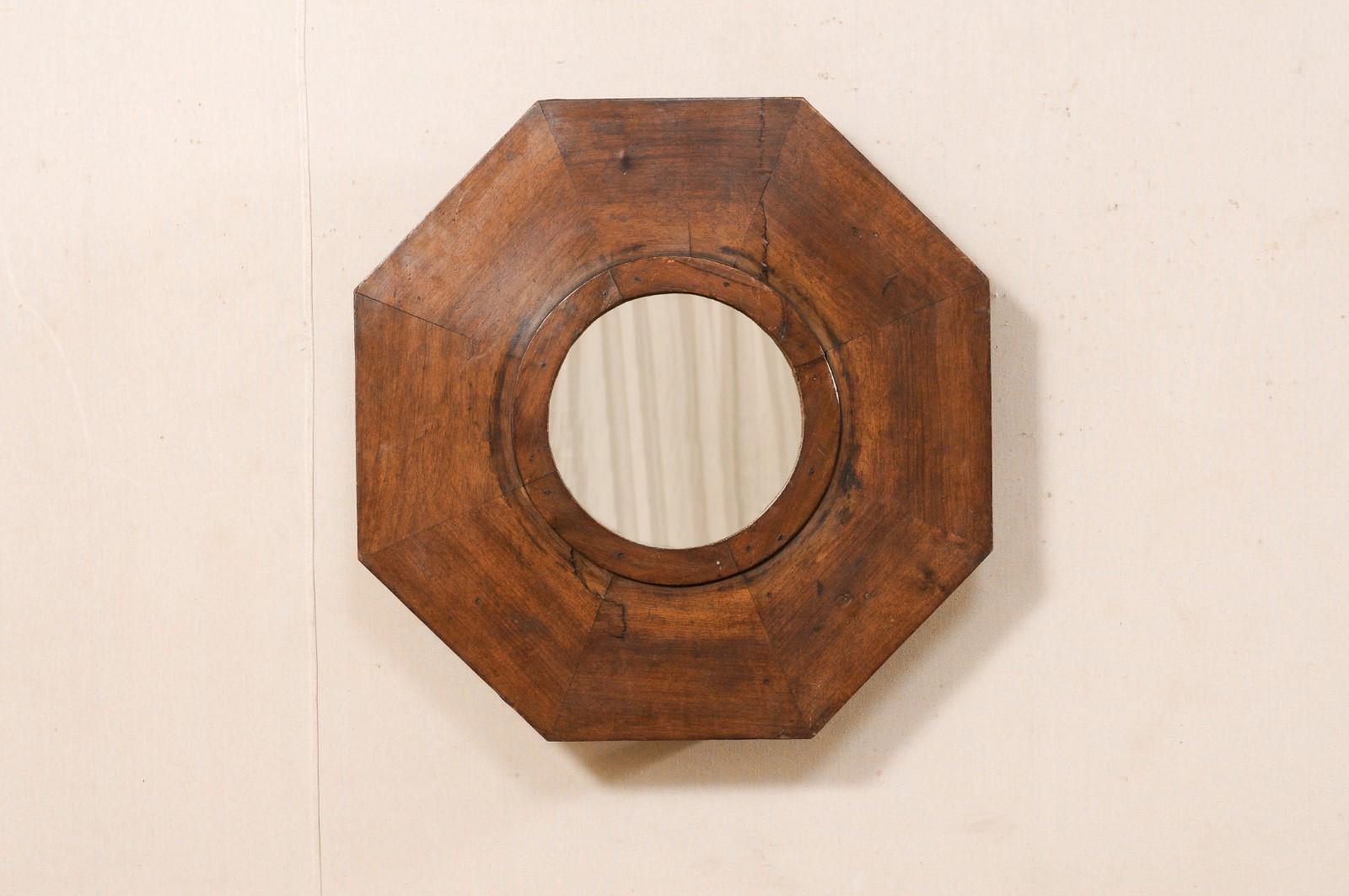A fantastic octagonal mirror which has been custom fashioned with an antique Spanish wooden brazier as the surround, with new mirrored glass in it's center. This wall decoration features a new, circular-shaped mirror at center, within a beautifully