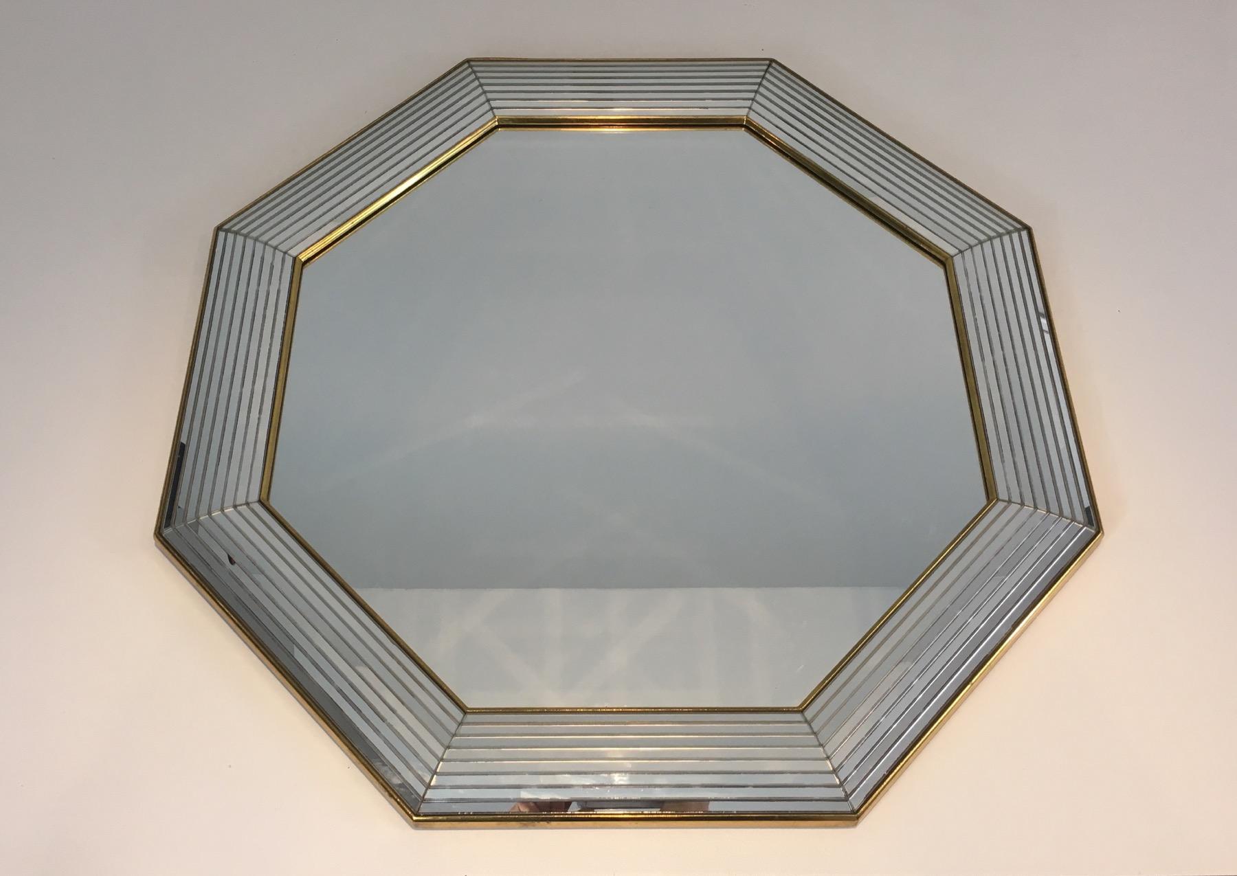 This decorative octagonal mirror is made of mirror and Lucite on the sides, separated by gilt wooden elements. This is a French work, circa 1970.