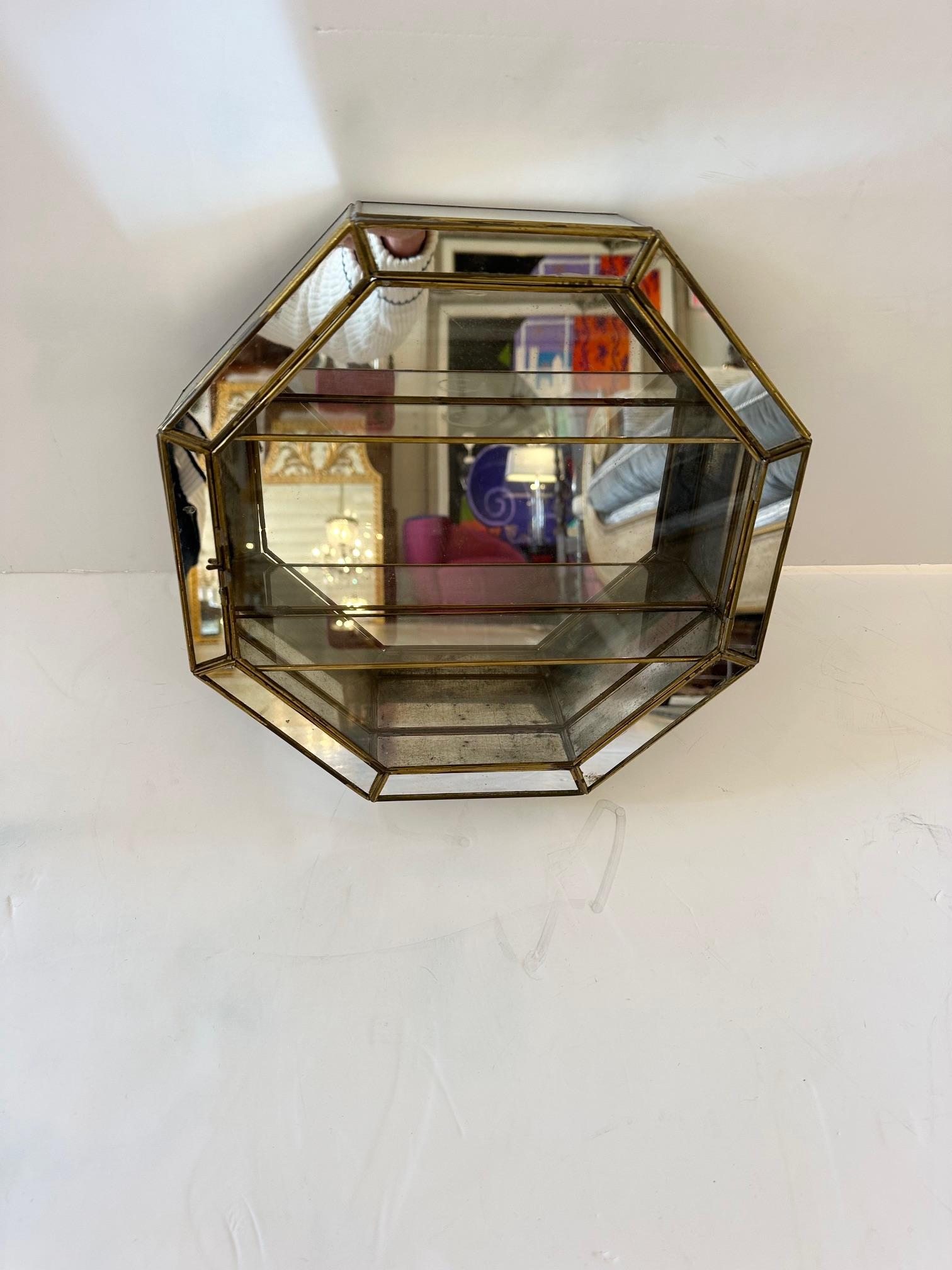 Achteckige Wandvitrine aus Zinn, Messing und Spiegeln.
2 Innenböden
