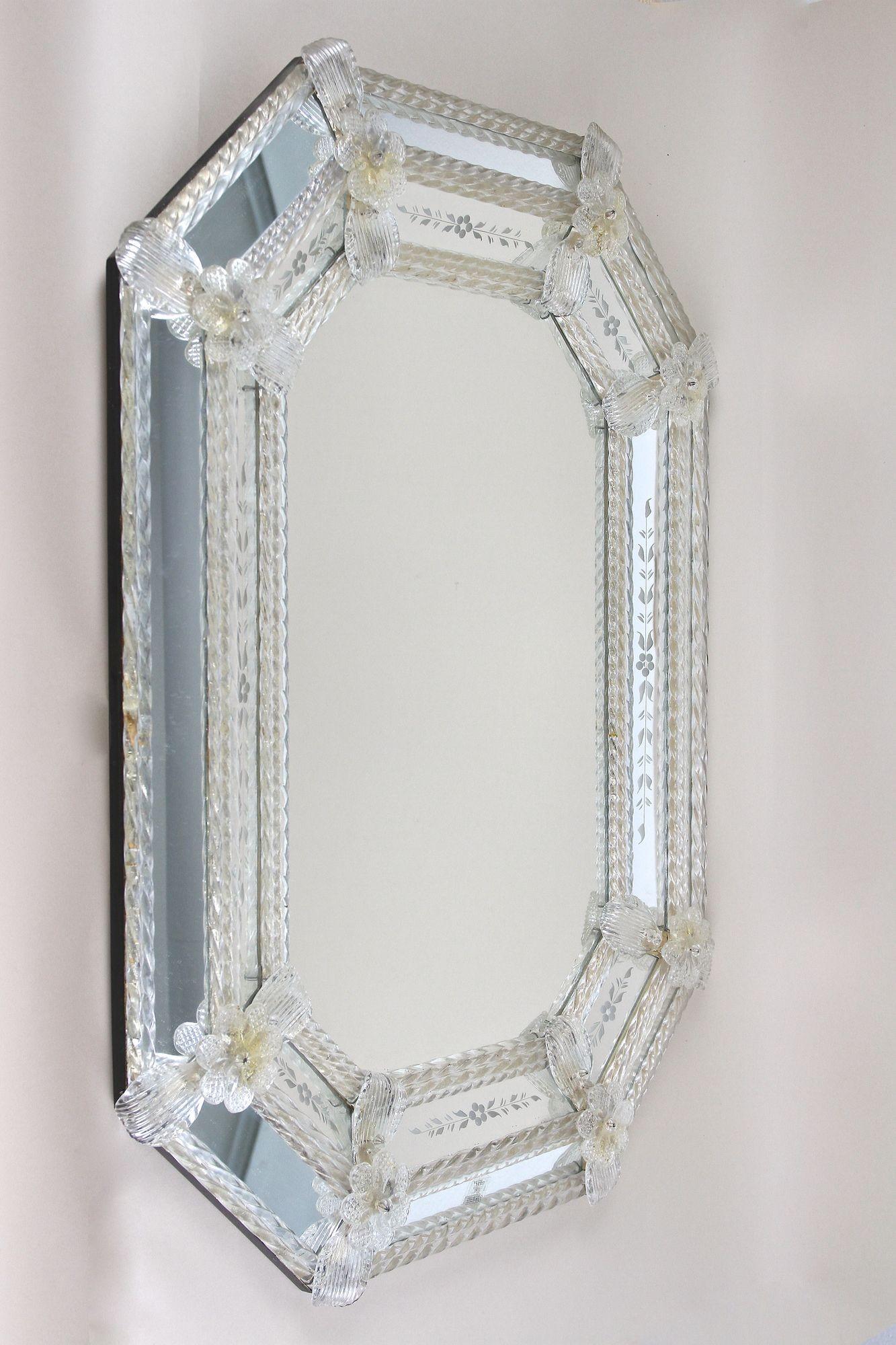 Absolute stunning late mid century Murano glass mirror from the famous workshops of the little island in Venice/ Italy. This extraordinary piece of an octagonal murano wall mirror impresses with amazing details wherever you look. Artfully